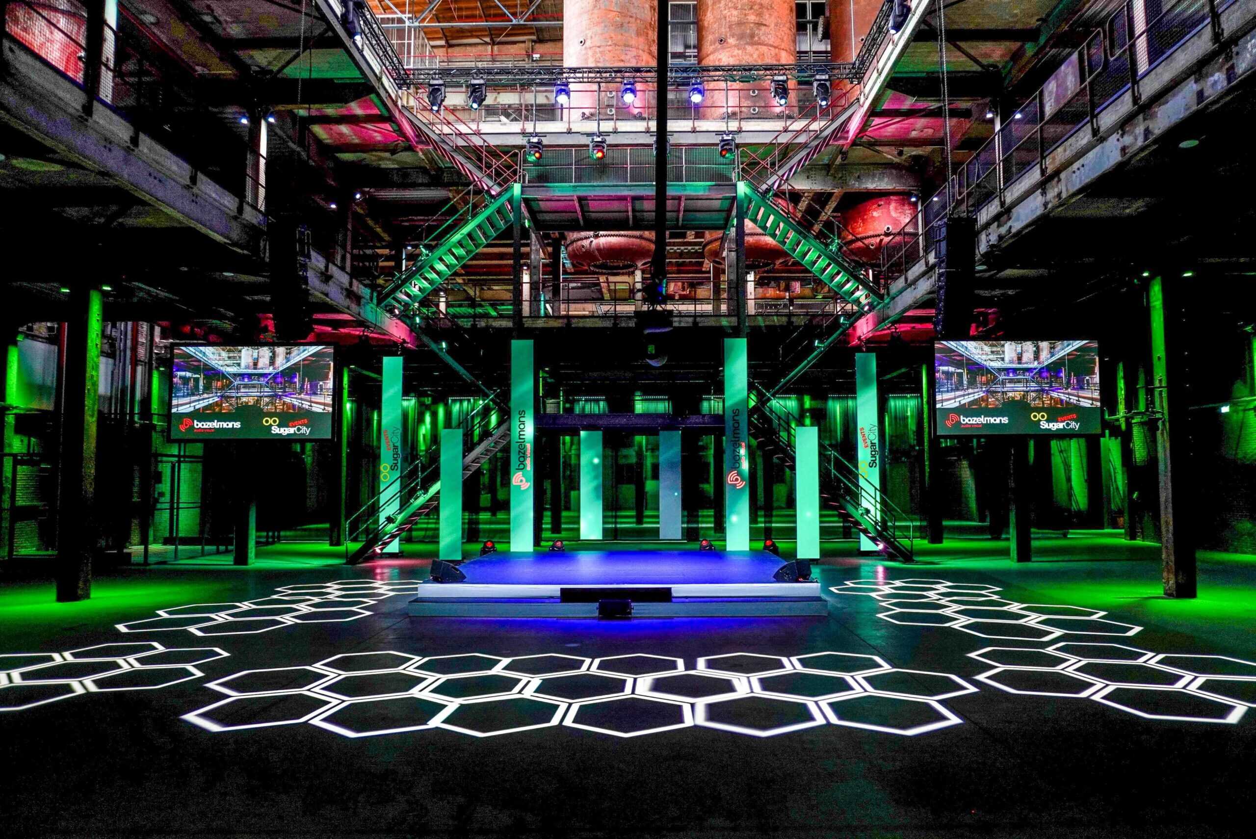 Hybride evenementlocatie met kleurrijk licht en technologische elementen.