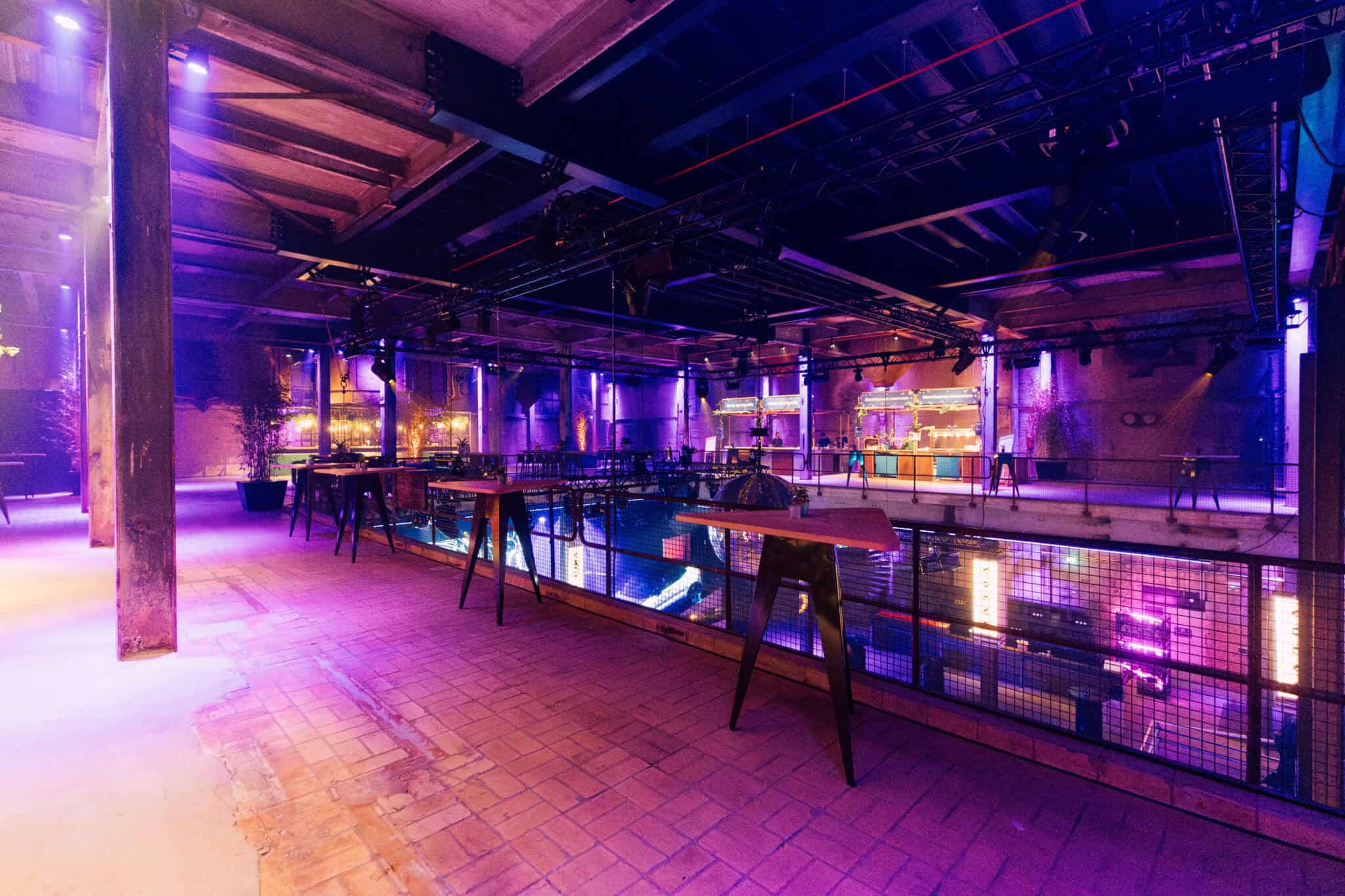 Middenfabriek interieur met kleurrijke verlichting en industriële uitstraling.