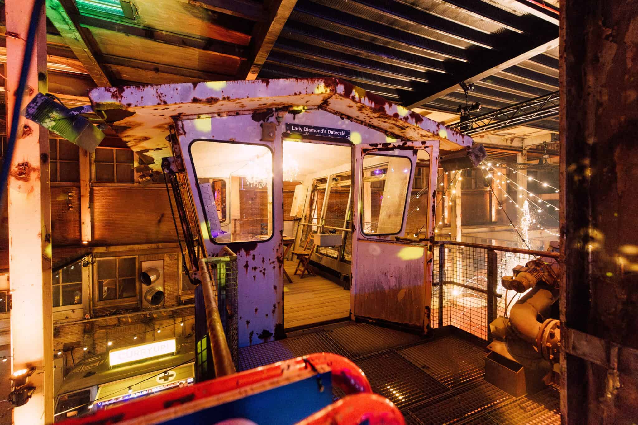 Kermisattractie in de oude Middenfabriek met kleurrijke lichten en nostalgische sfeer.