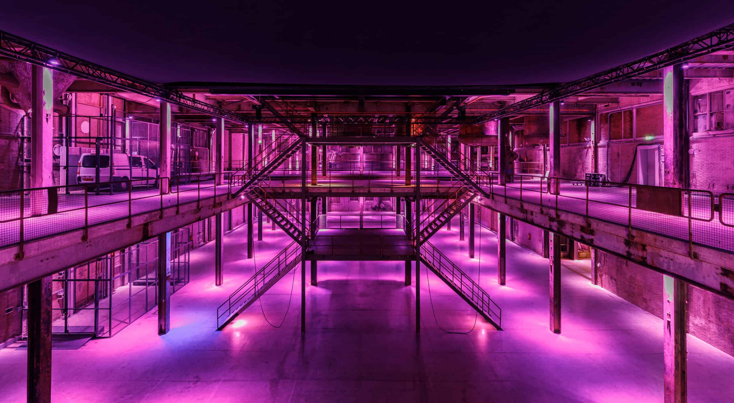 Middenfabriek met kleurrijk neonverlichting en industriële architectuur, perfect voor creatieve even.