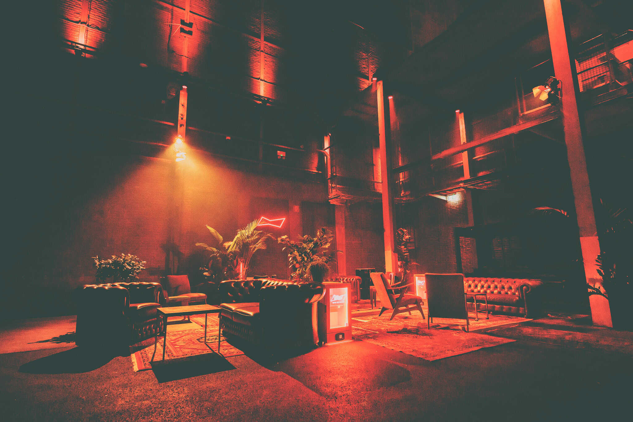 Industriële Pulpersloods met lounge zithoeken en warme verlichting.