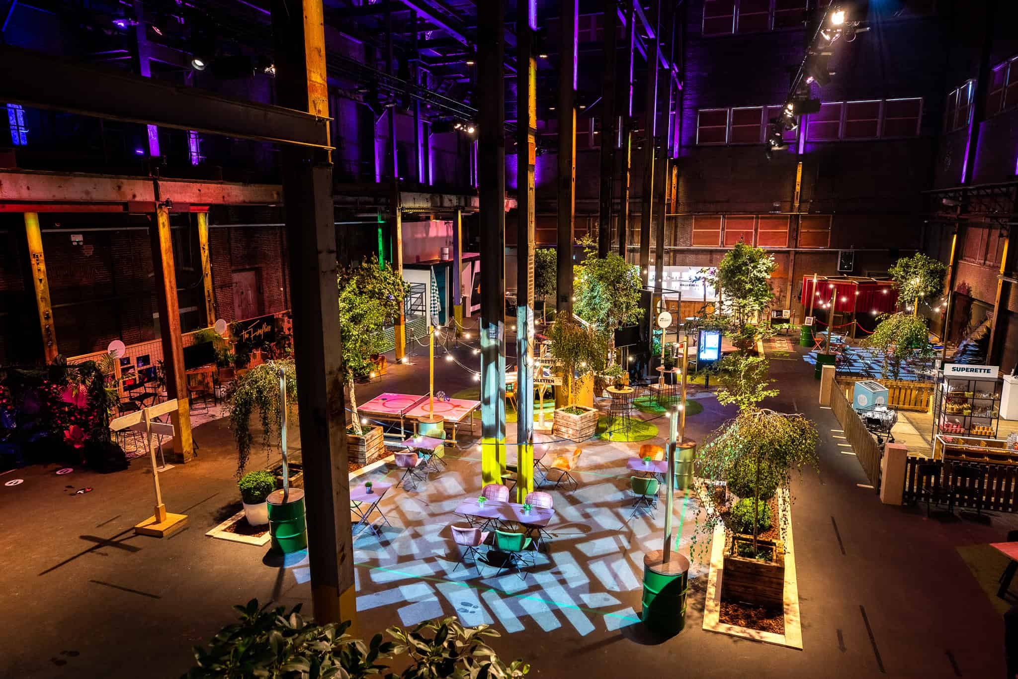 Pulppersloods interieur met dansvloer, kleurrijke verlichting en groene planten, geschikt voor evene.