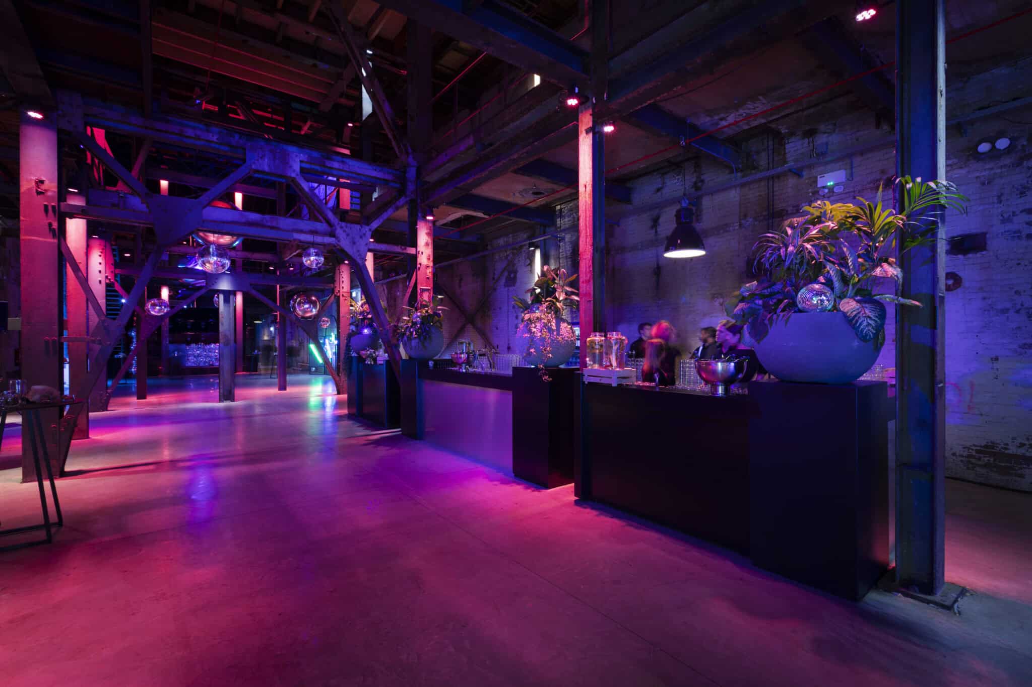 Binnenstraat bij SugarFactory met kleurrijk verlichte industriële sfeer.