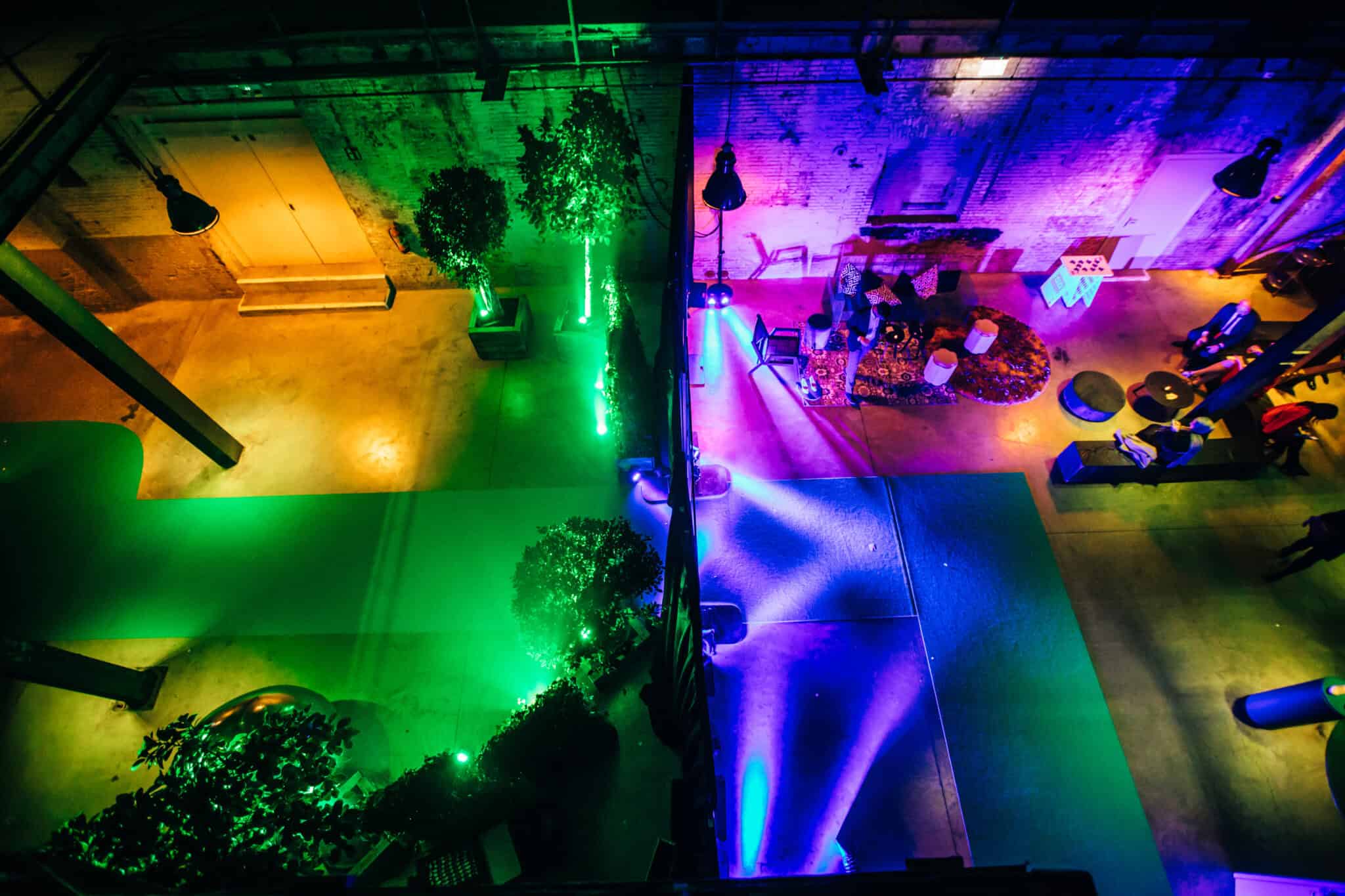 Vloer met groene en blauwe LED-verlichting in Binnenstraat, met zitplaatsen en decoratieve planten.