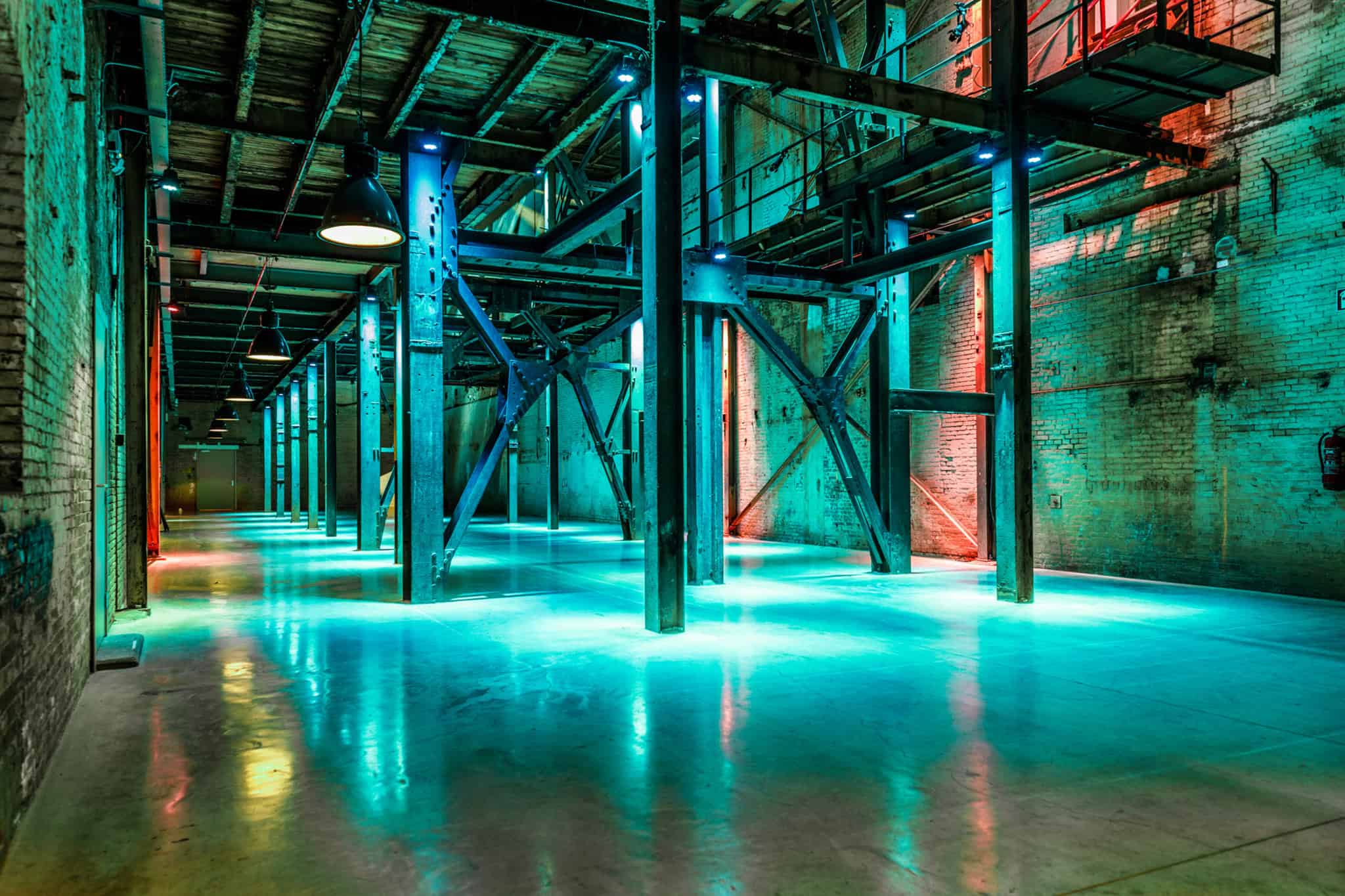 Industrieel interieur in de Binnenstraat met levendige blauwe en rode verlichting.