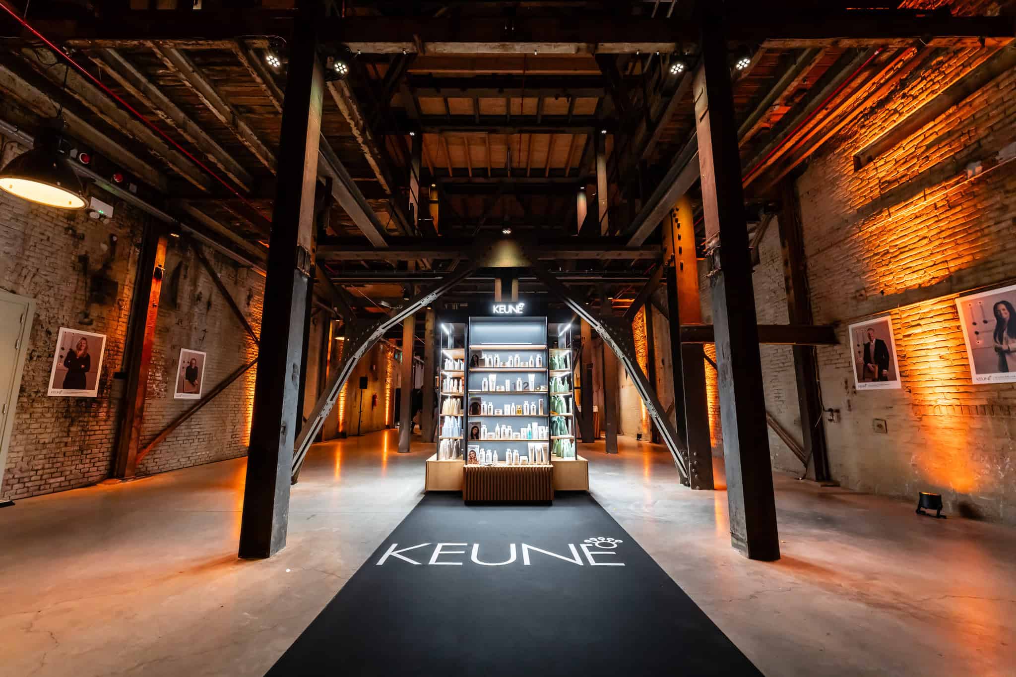 Modern Keune salon binnenstraat met industrieel design en verlichte muur.