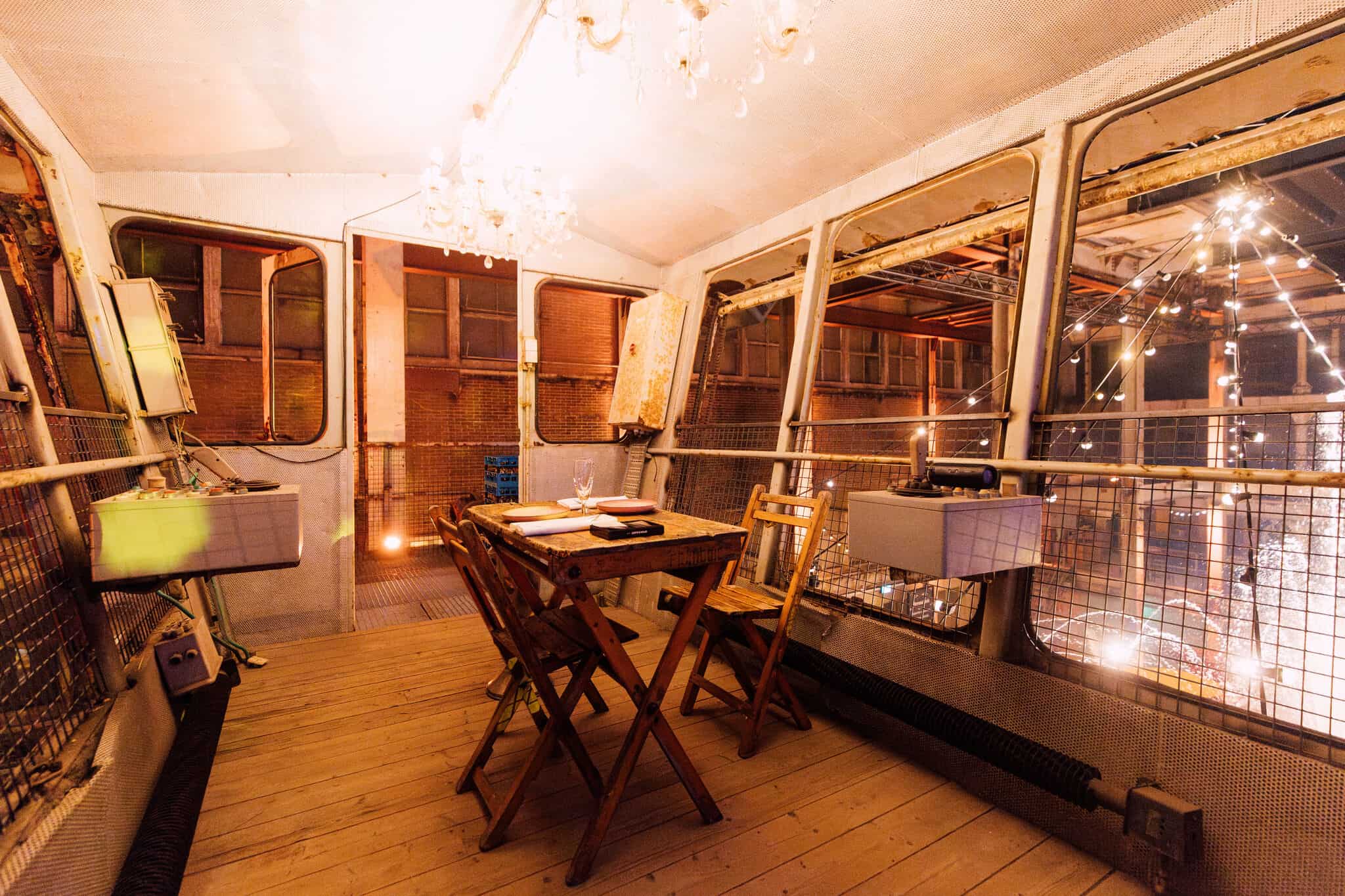 Binnenkant van de Middenfabriek met tafels en ramen, sfeervol verlicht.