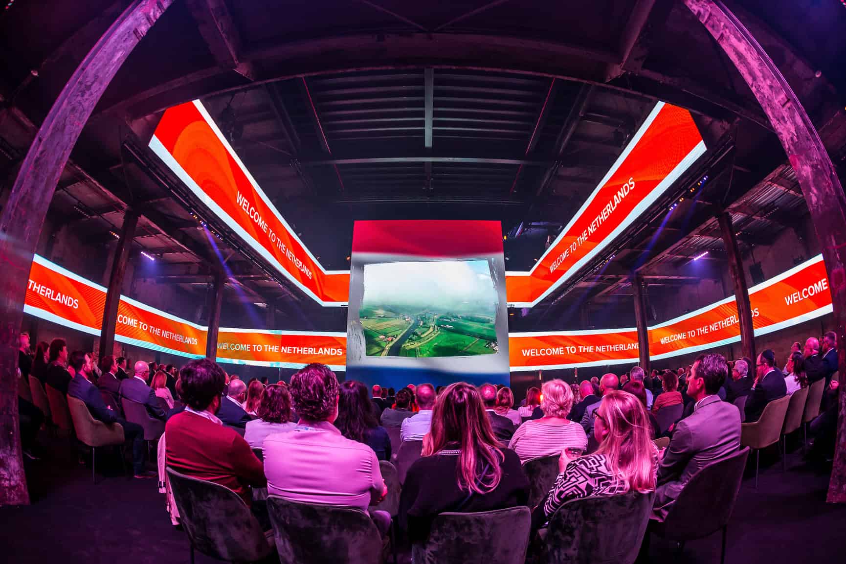 Evenement in de Middenfabriek met grote schermen en publiek.
