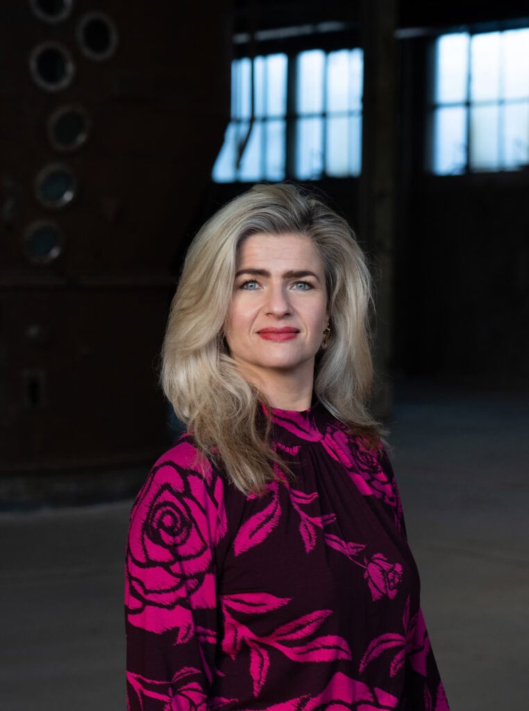 Sabine Fredriks, nieuwe directeur van SugarFactory, poseert in een industrieel gebouw.