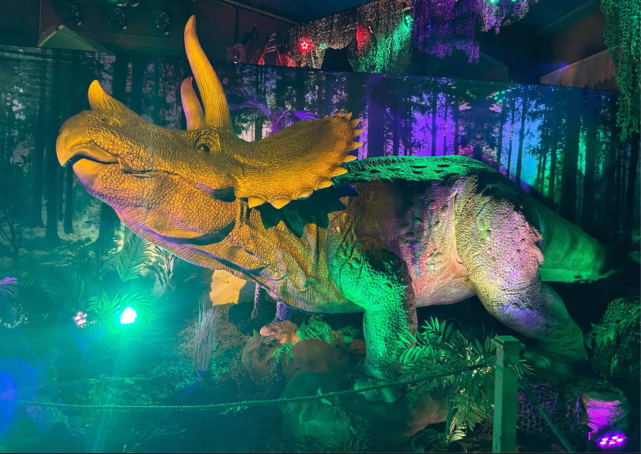 Grote dinosaurus in jungle setting met kleurrijk licht.