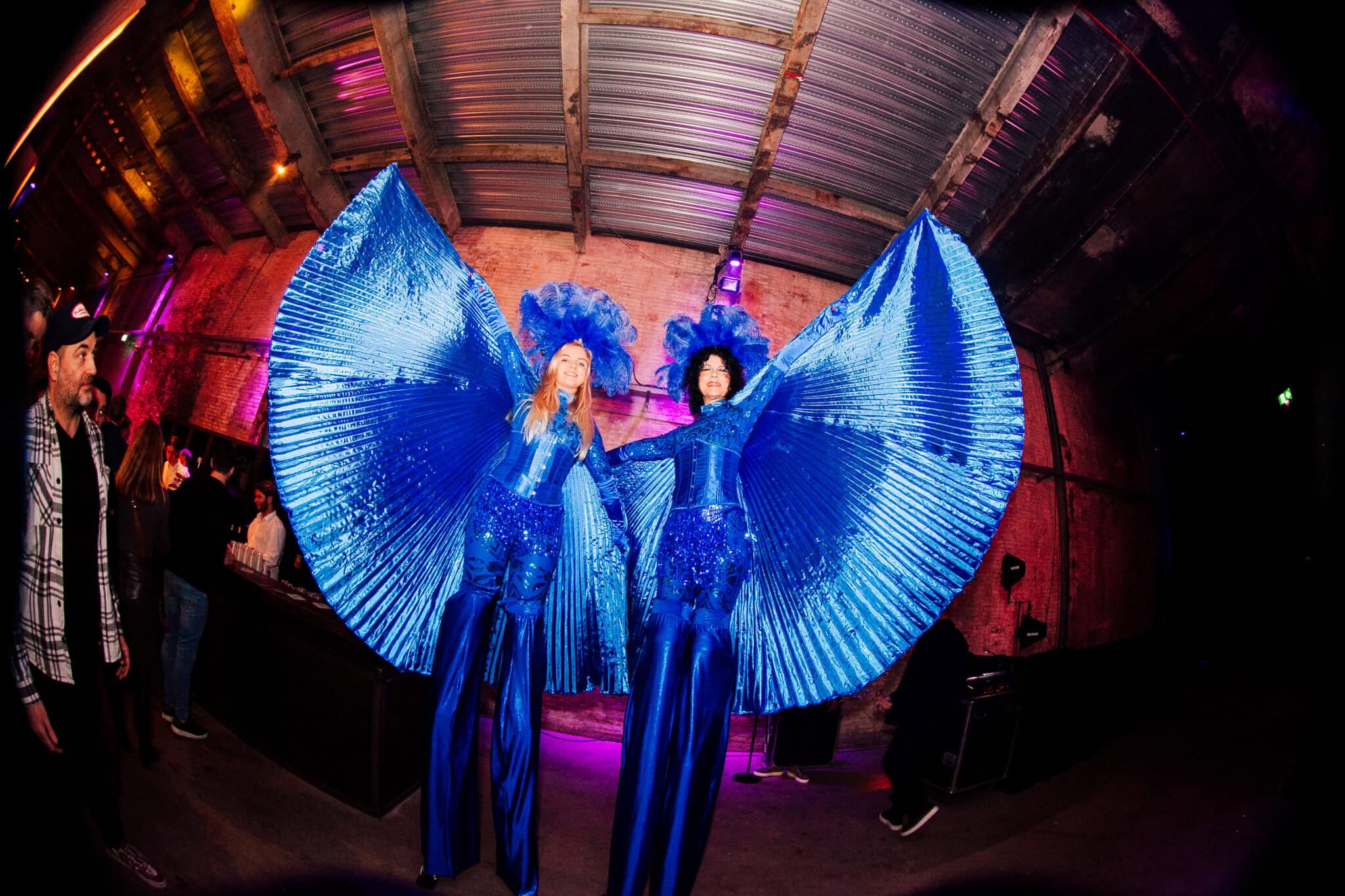 Vliegende performers in opvallende blauwe kostuums met grote vleugels.