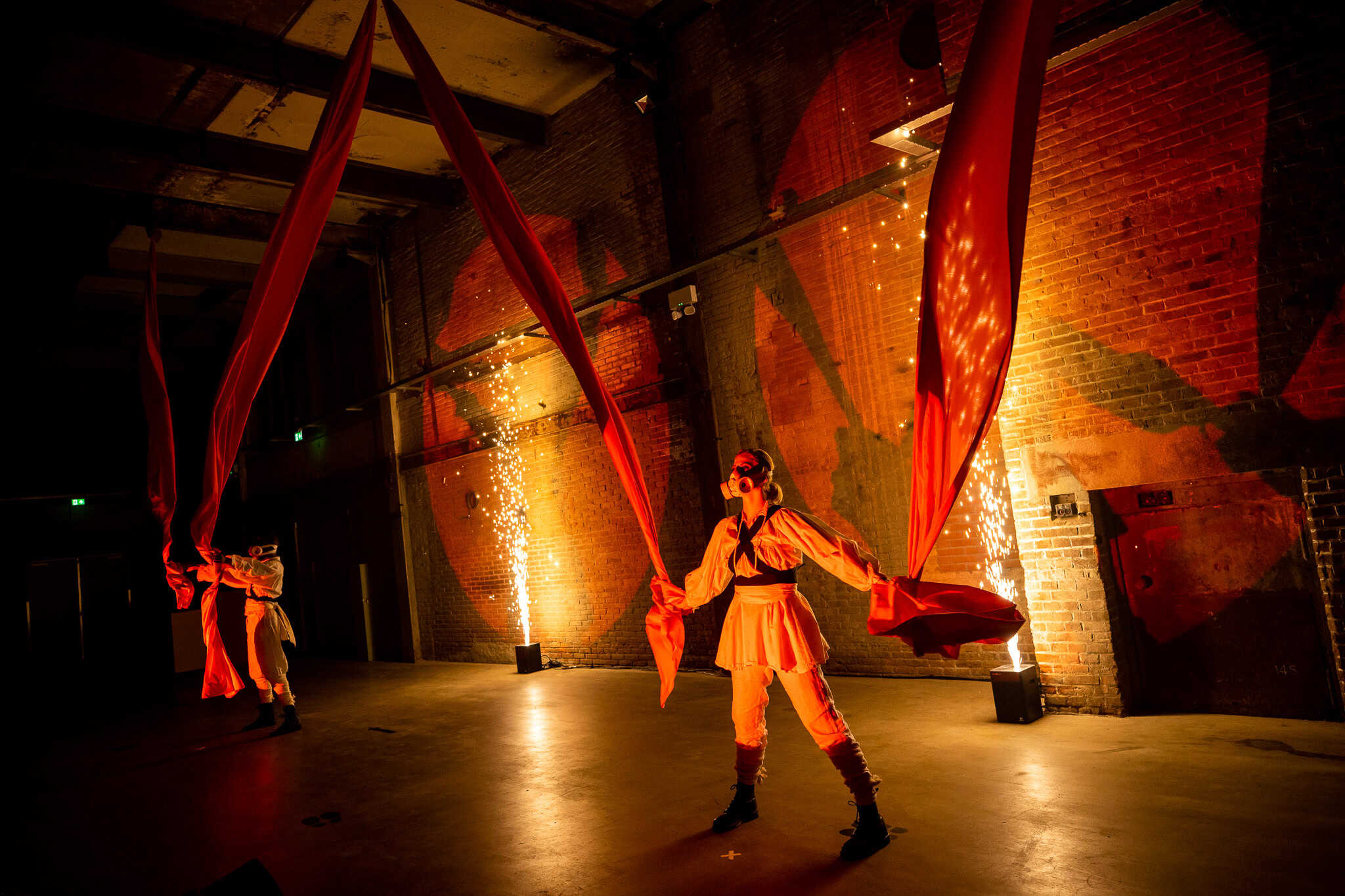 Performers with red fabric in industrial-style venue at SugarFactory.