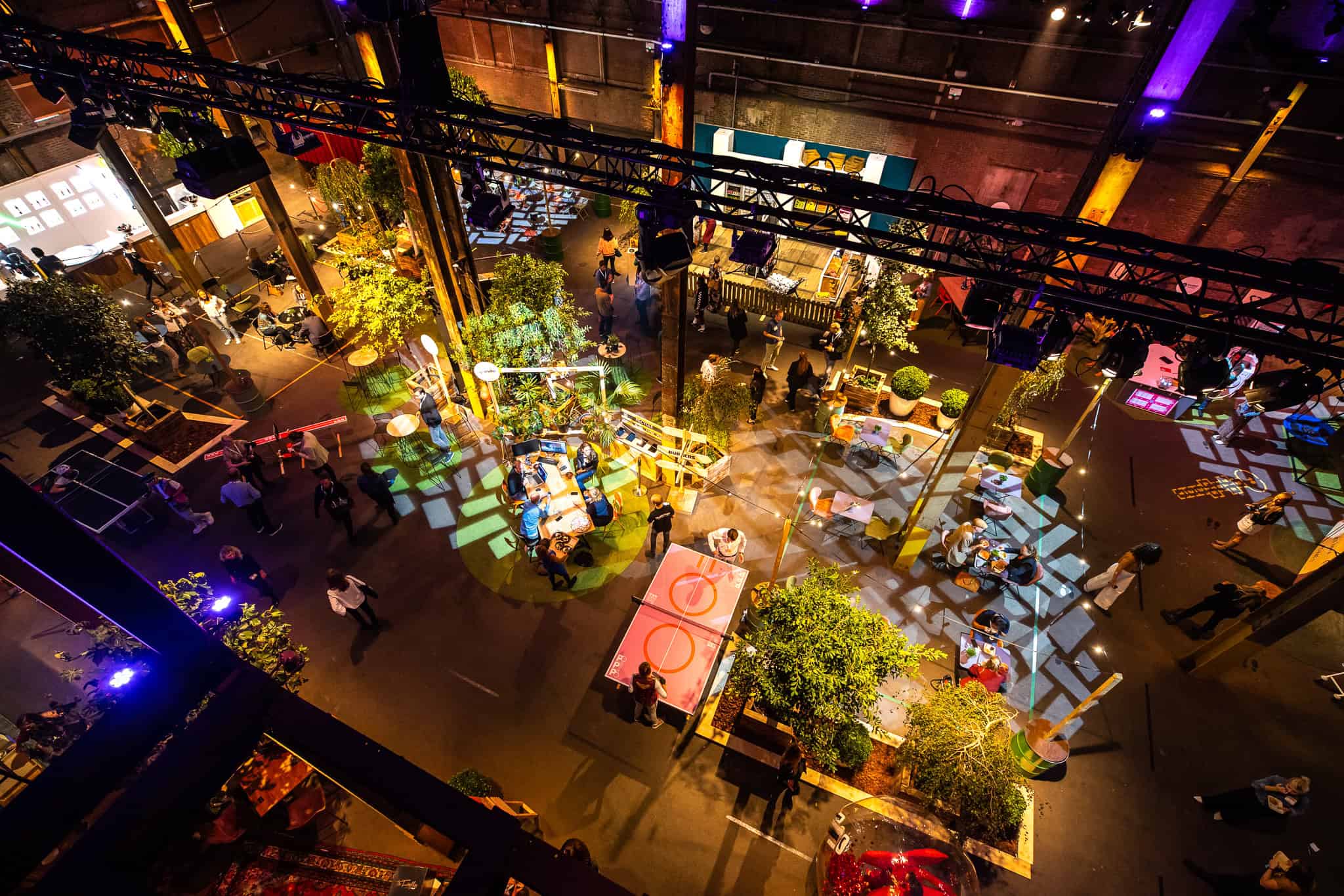 Gezellige sfeer bij SugarFactory met kleurrijke verlichting en zitplaatsen.