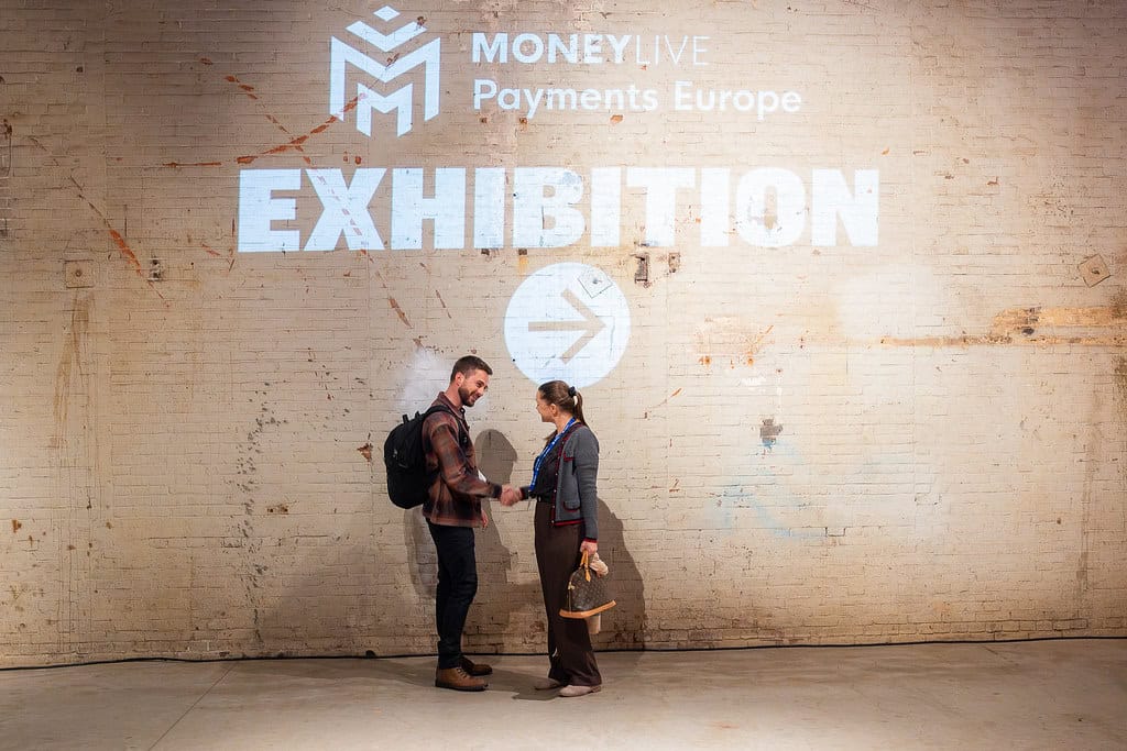 Expositie op beurs met twee mensen die handenschudden.