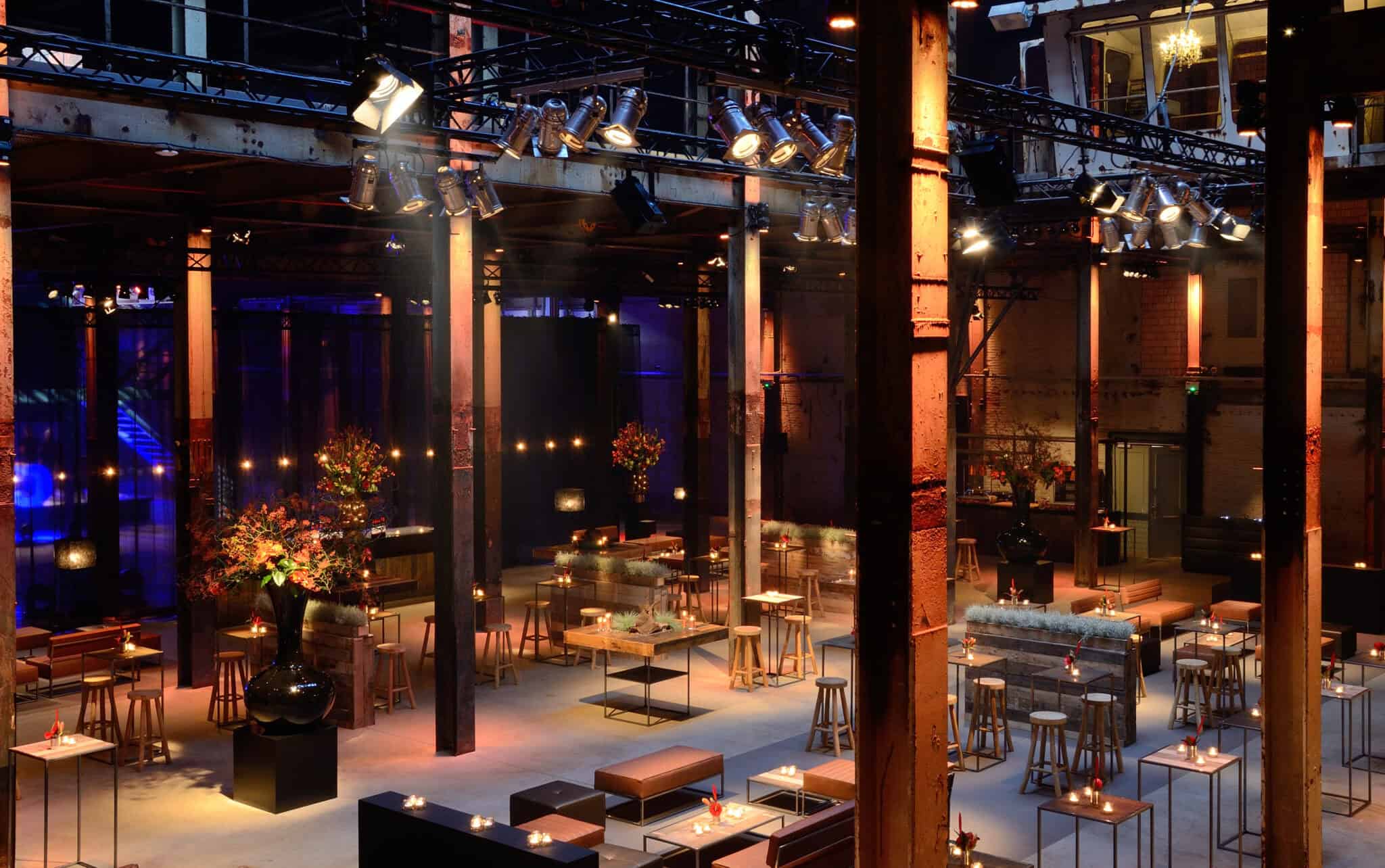 Industrieel interieur met sfeervolle verlichting en gezellige zitplaatsen.