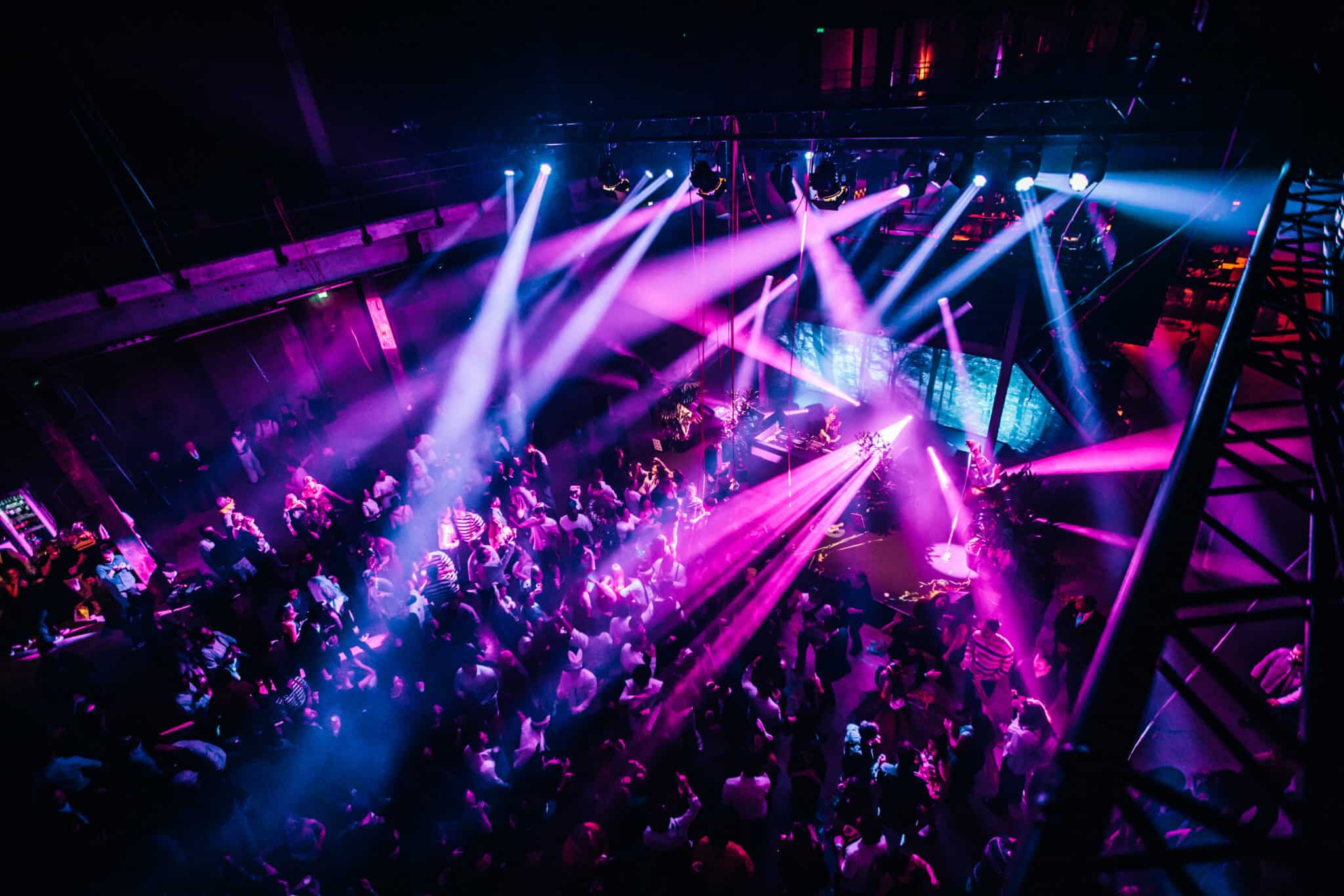 Dansfeest met kleurrijke lichtshow en enthousiaste gasten.