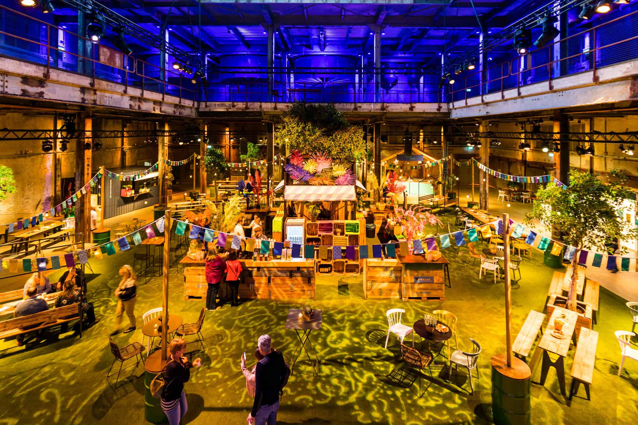 Personeelsfeest in een industrieel ingerichte locatie met decoraties en zitplaatsen.