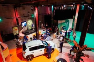Innovatieve productpresentatie met auto en publiek in industriële setting.