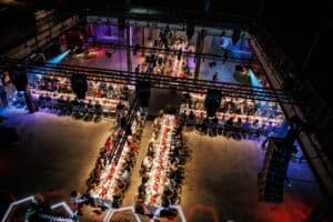 Gezellig diner met lange tafels en sfeervolle verlichting.