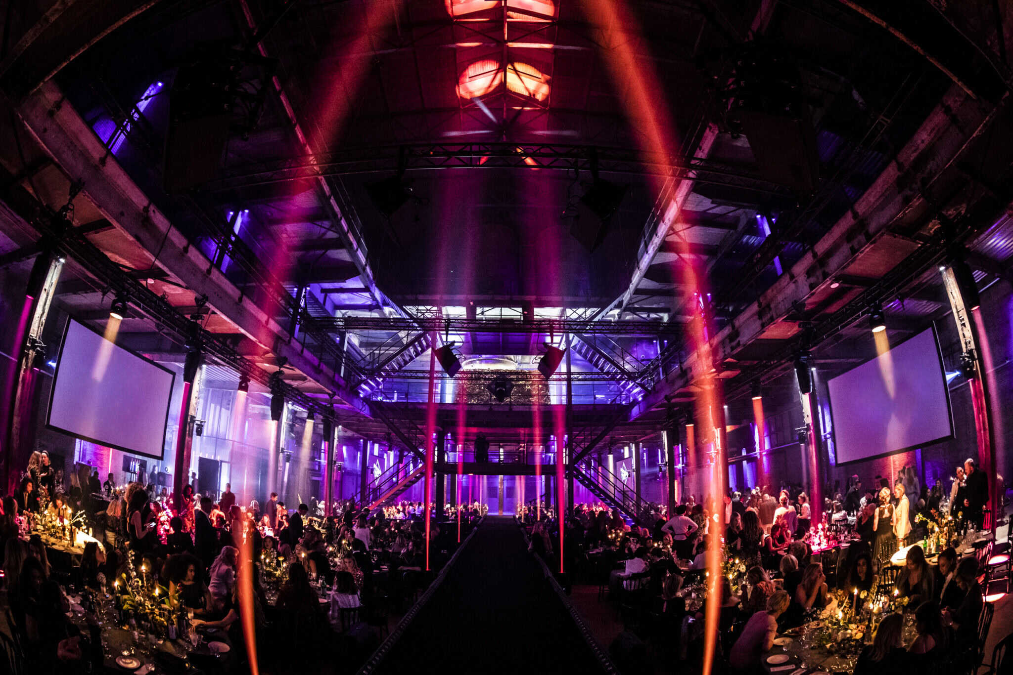 Gezellig diner in een sfeervolle zaal met kleurrijke verlichting en feestelijke ambiance.