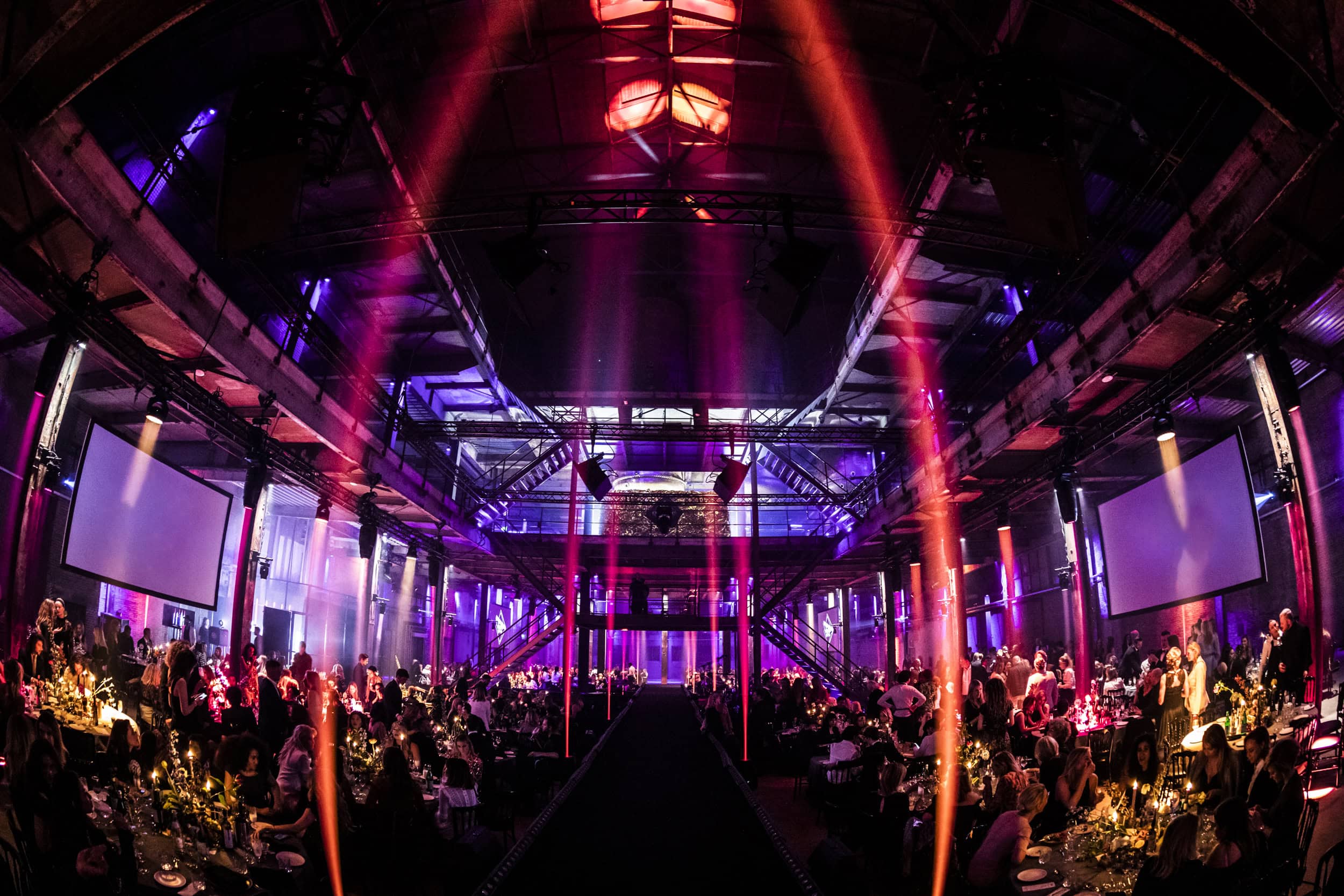 Gezellig diner in een sfeervolle zaal met kleurrijke verlichting en feestelijke ambiance.