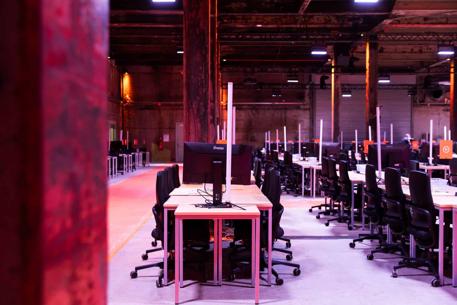 Hackathon gaming en werkruimte met meerdere computers en stoelen.