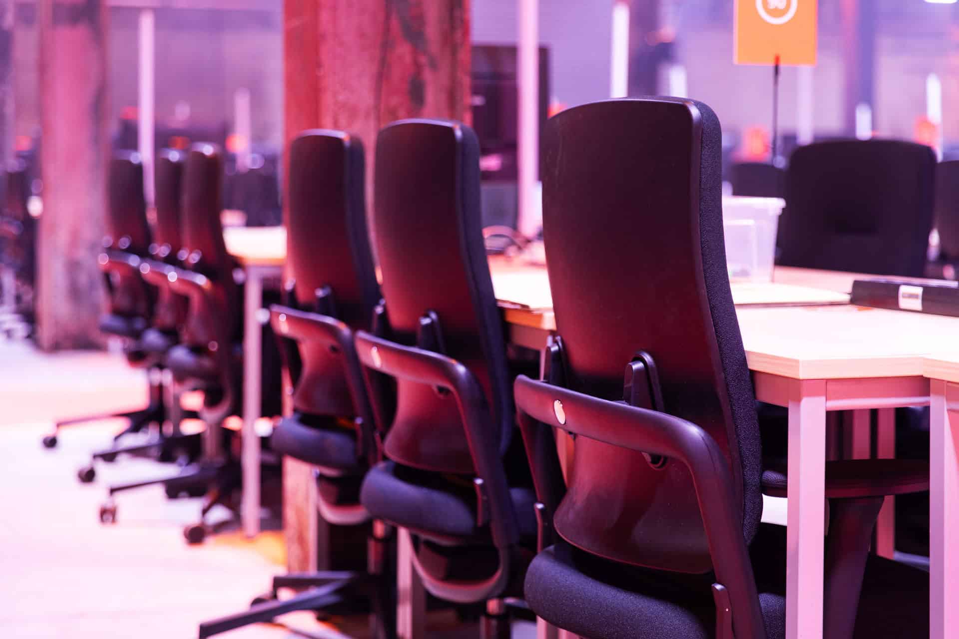 Moderne vergadertafel met zwarte stoelen voor Hackathon-evenement.