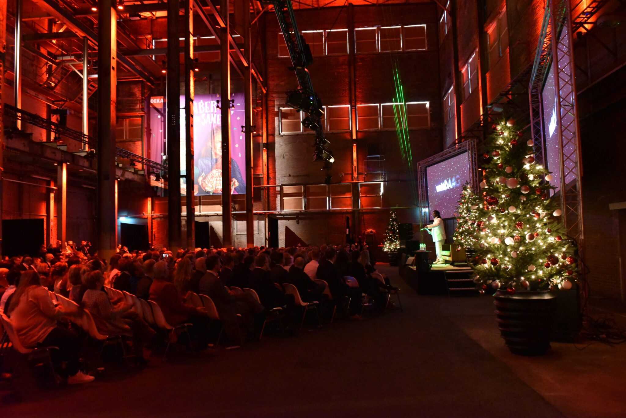 Presentatie evenement met publiek en kerstboom bij Detailresult Groep tijdens feestdagen.