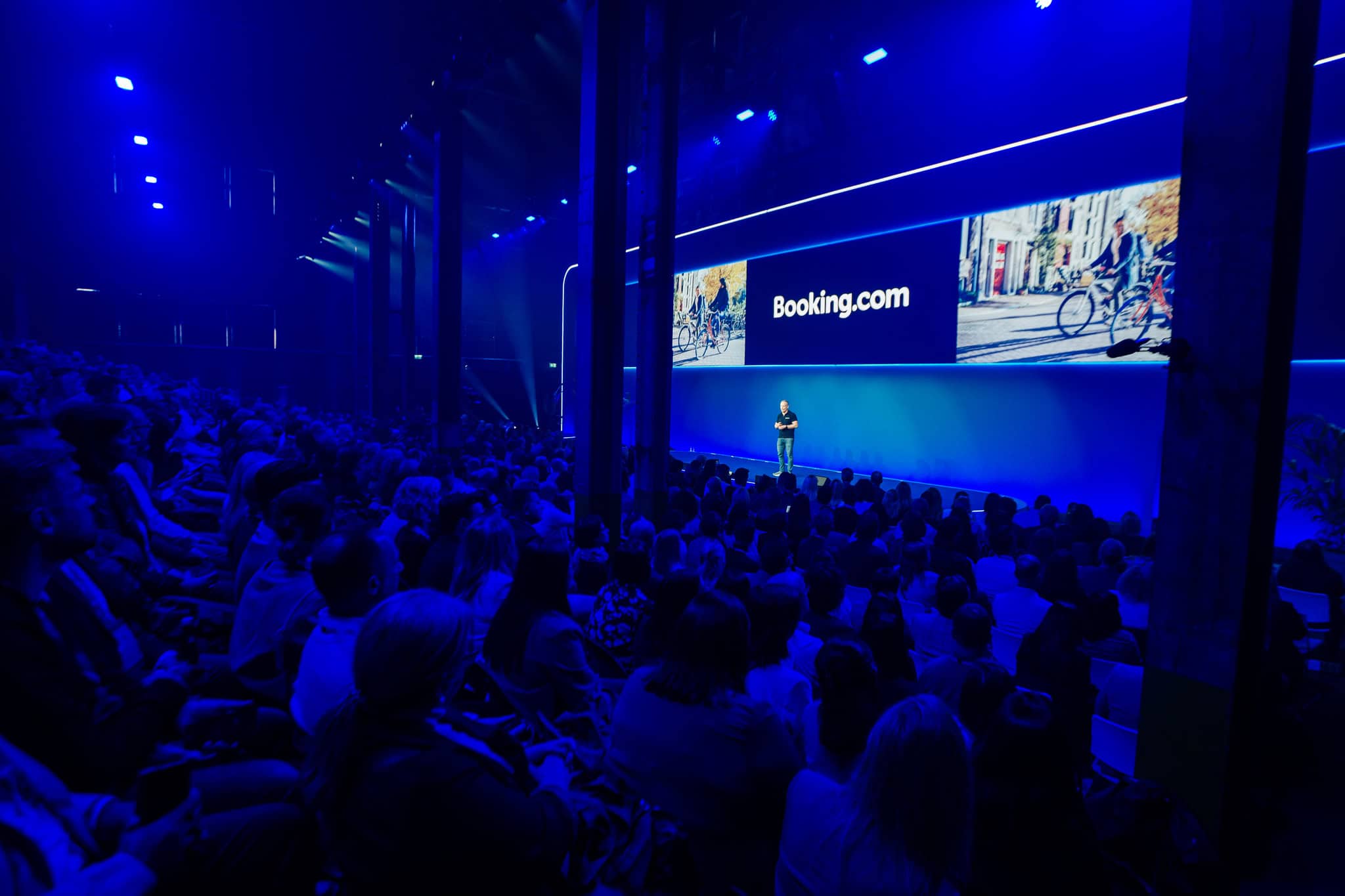 Groots congres in de SugarFactory met veel deelnemers en een spreker op het podium.