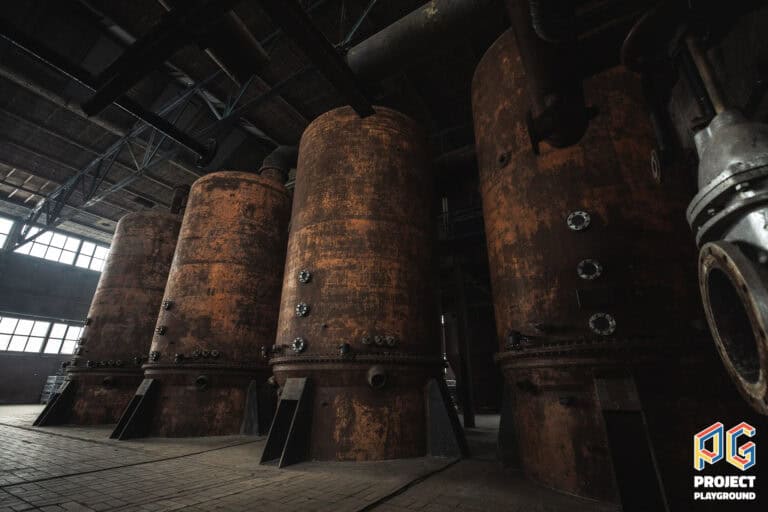 Kolen voor distillatieproces in distilleerderij, grote roestige tanks voor alcoholproductie.