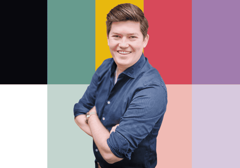 Personeelslid van SugarFactory poseert met glimlach voor kleurrijke achtergrond, benadrukt teamgeest.