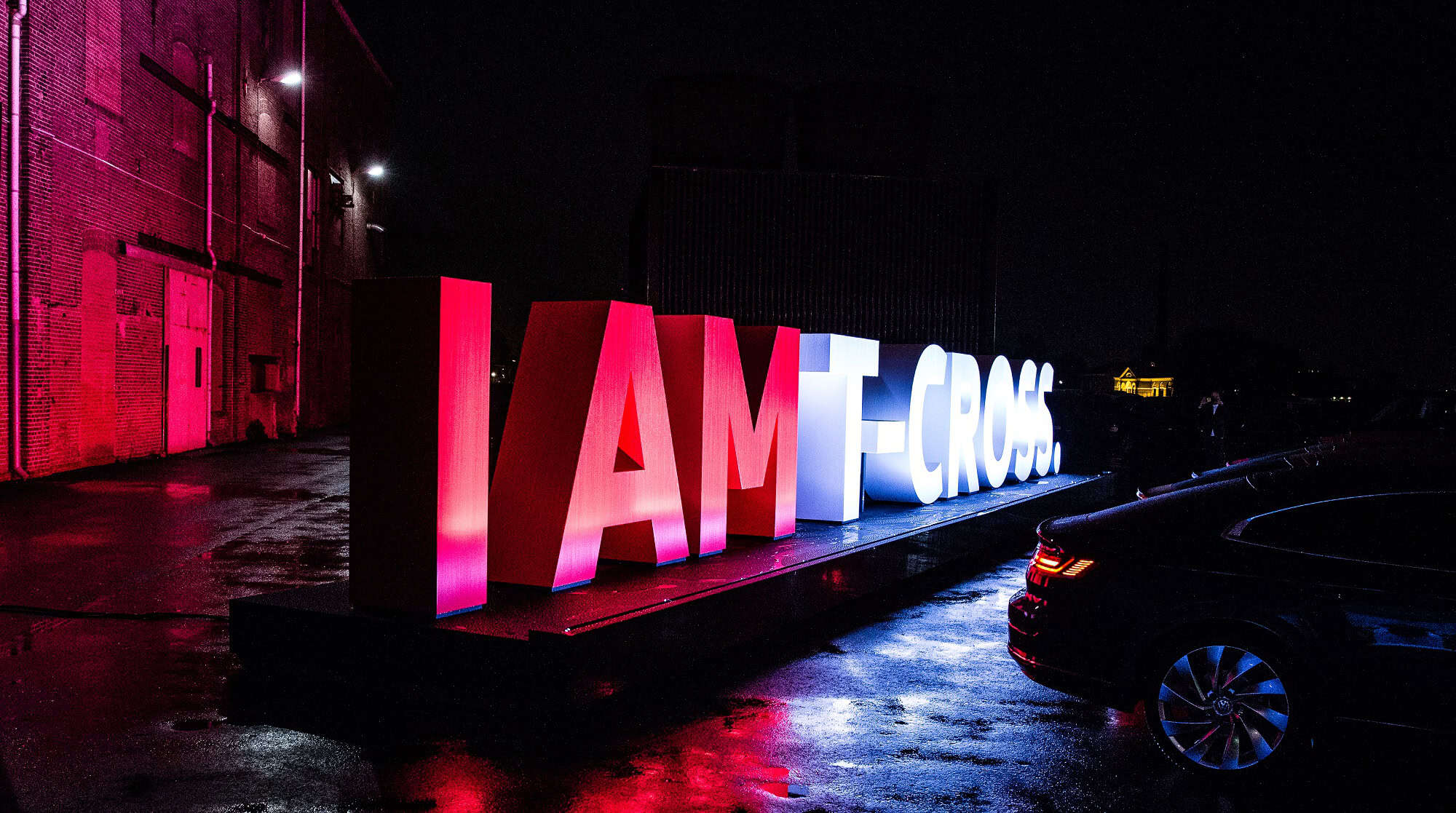 Volkswagen T-Cross wereldpremière met verlichte letters bij nacht.