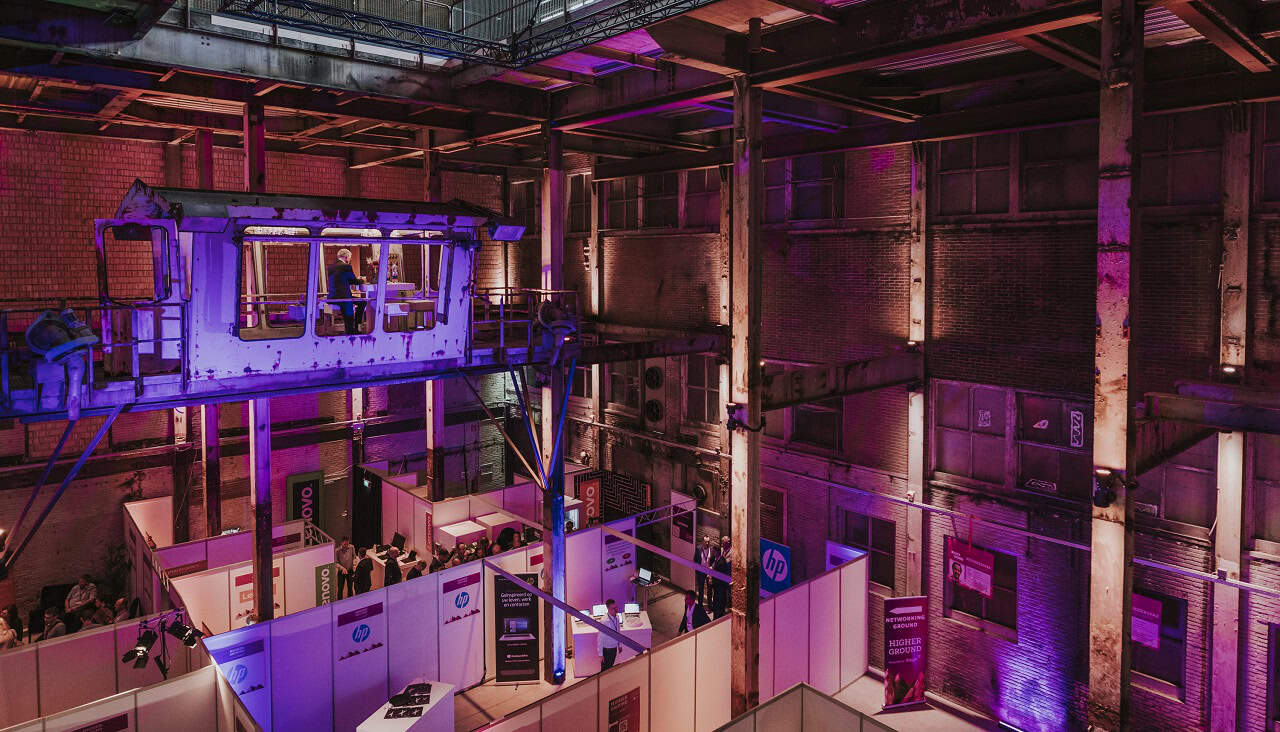 Industriële lift met kleurrijk verlichte omgeving tijdens Higher Ground Tech Kongress.