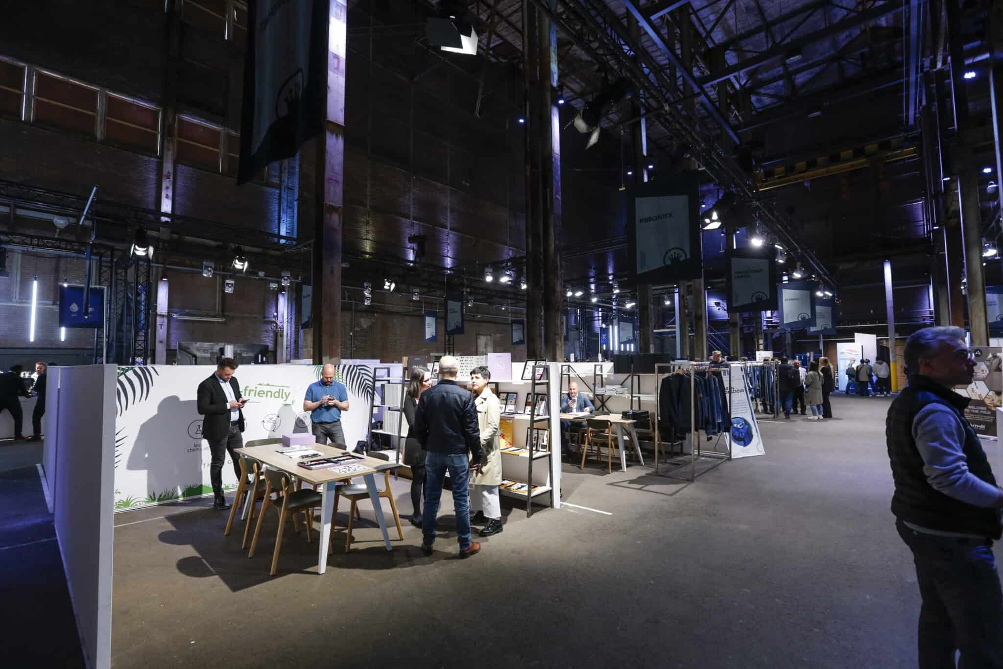 Beursstand op Kingpins Show met bezoekers en displays in een grote industriële hal.