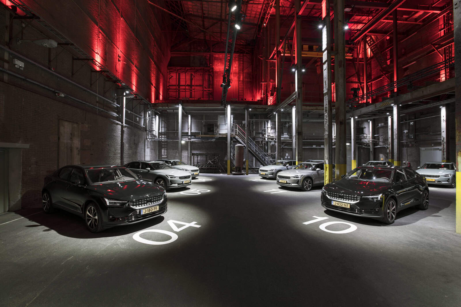 Autodepot met luxe auto's voor productpresentatie in industriële setting.