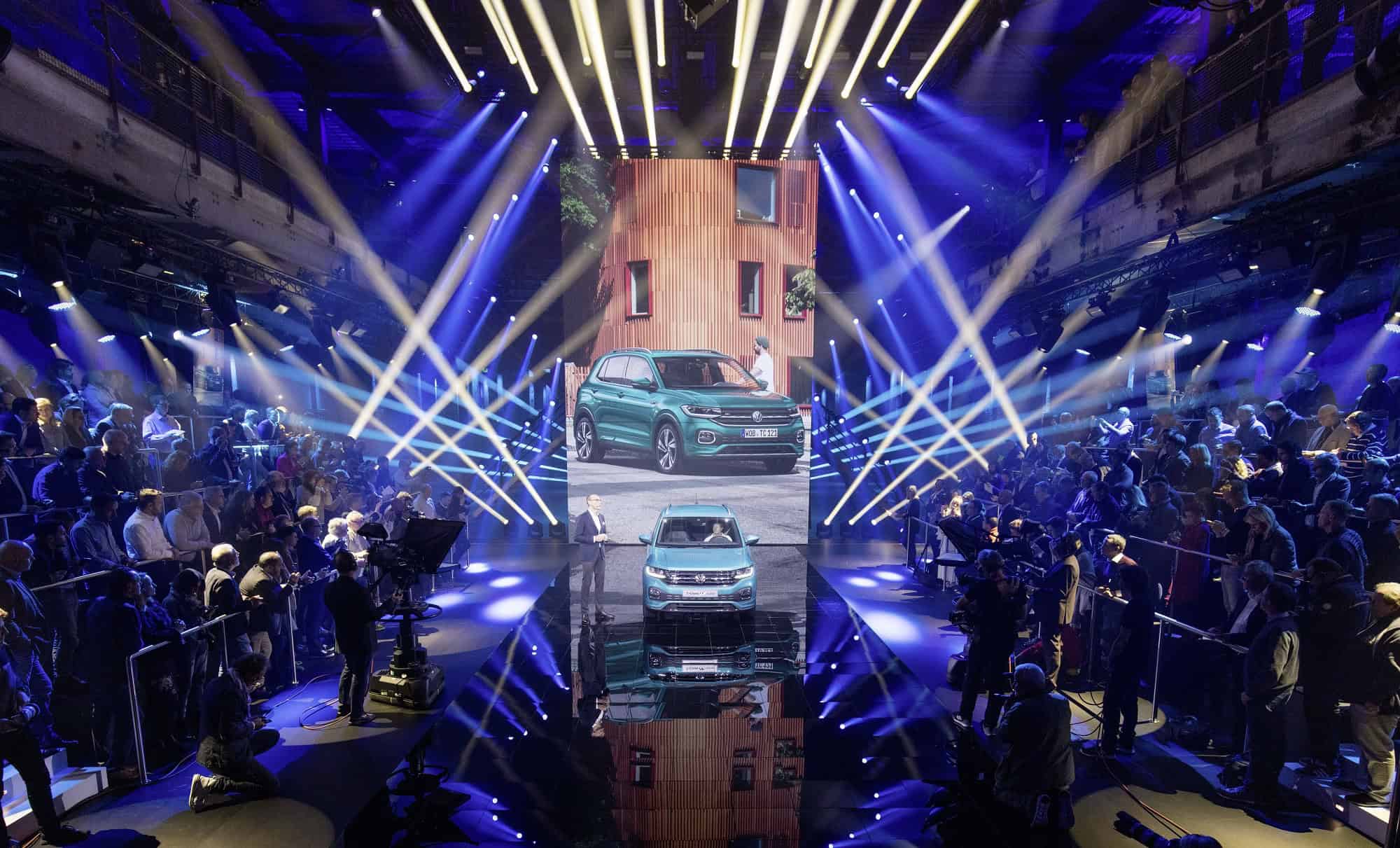 Auto presentatie op evenement met verlichte show en publiek.