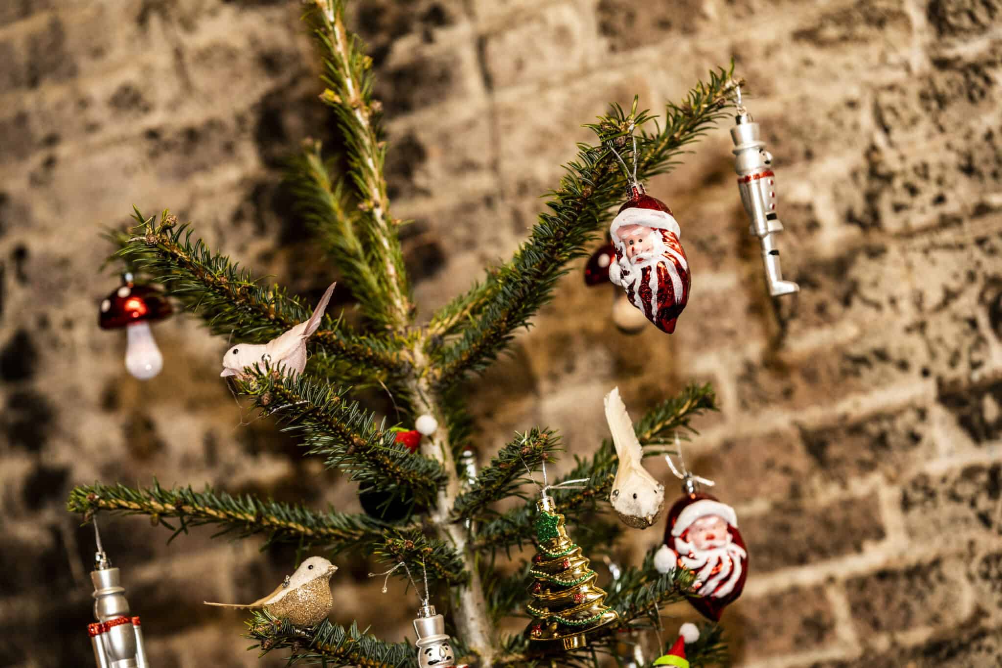 Kerstboom versierd met kerstballen en ornamenten in de bietenwasruimte.