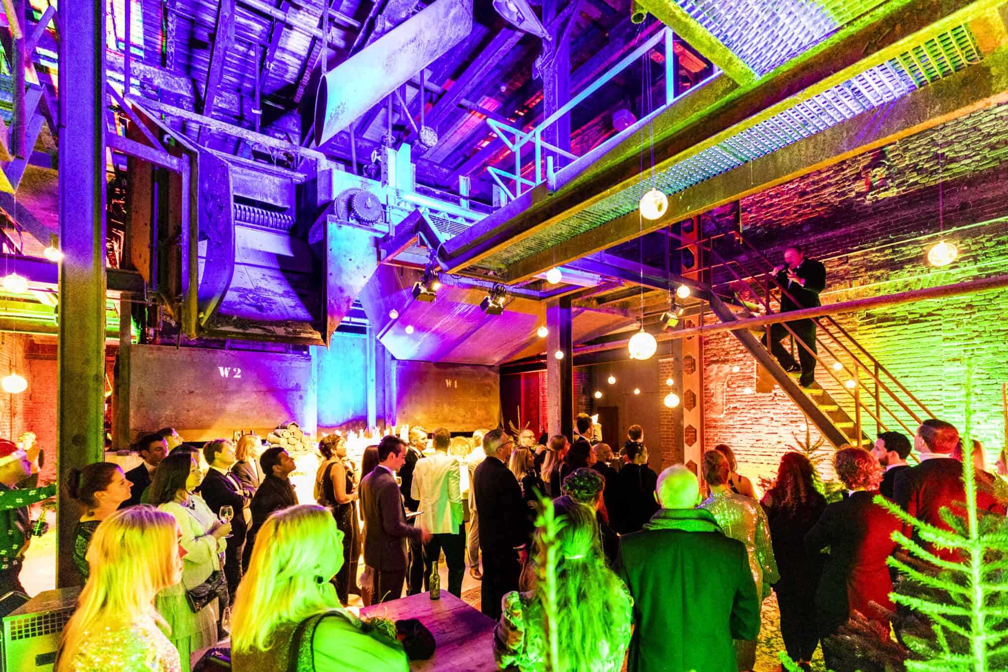 Kerstfeest in de bietenwasruimte met kleurrijk licht en feestende gasten.