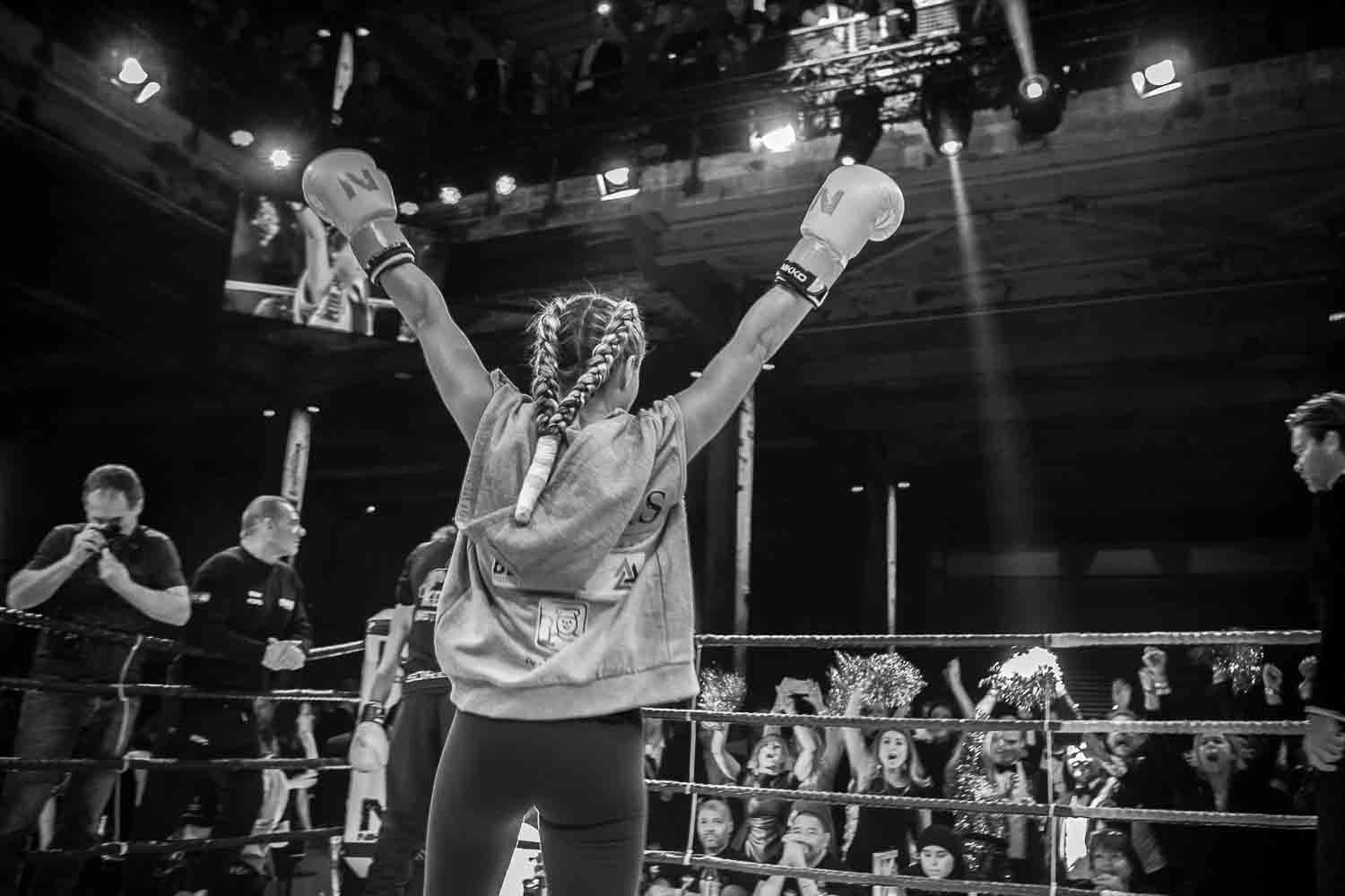 Vrouw met bokshandschoenen viert overwinning in de ring tijdens VHV Boxgala op SugarFactory.