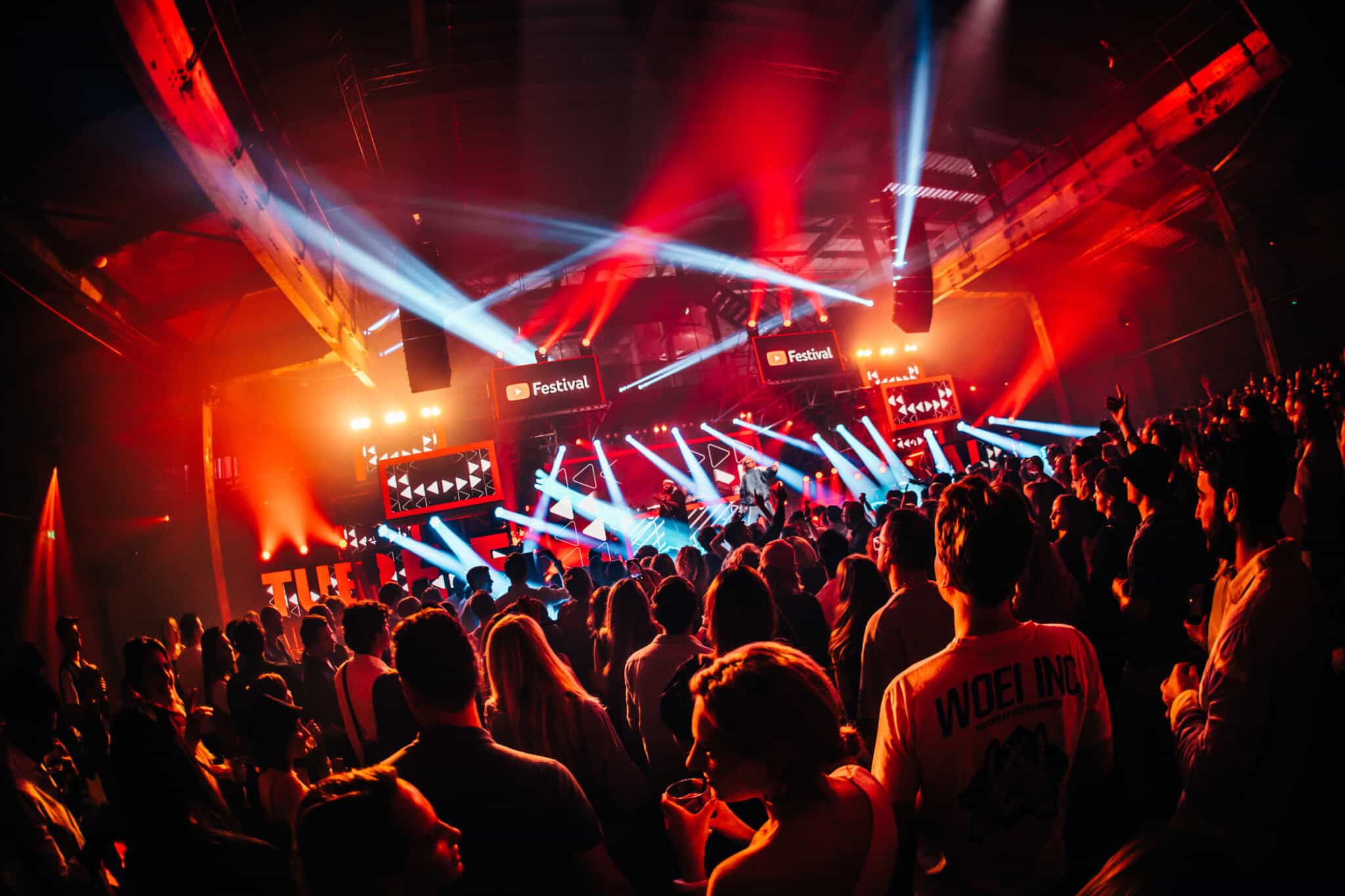 Festivaloptreden met kleurrijk licht en publiek.