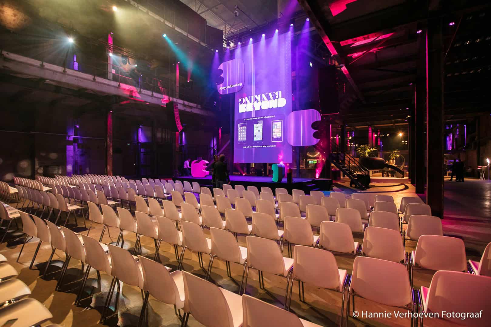 Innovatie Hub tijdens Beyond Banking Hackathon met kleurrijk licht en grote schermen.