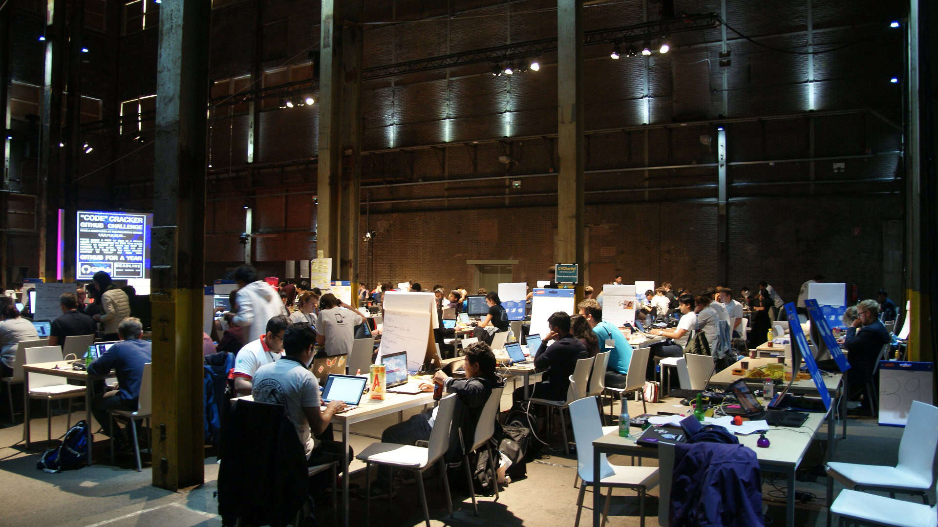 Groep mensen werkt samen in een grote werkruimte bij SugarFactory.