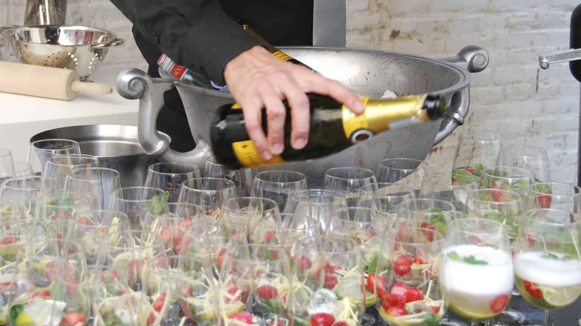 Barman schenkt mousserende wijn in glazen voor een feestelijke gelegenheid.