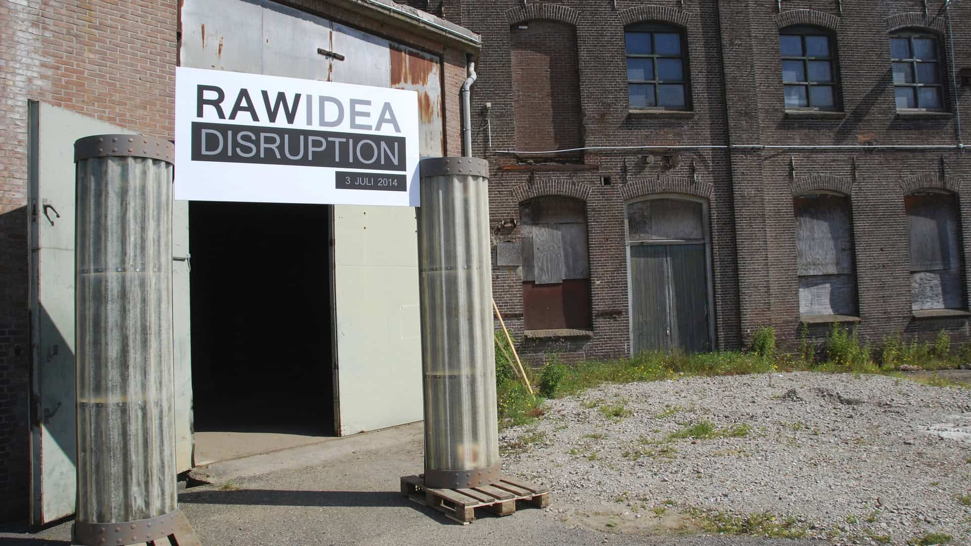 Ingang van RAW IDEA DISRUPTION evenement bij oude fabriek.