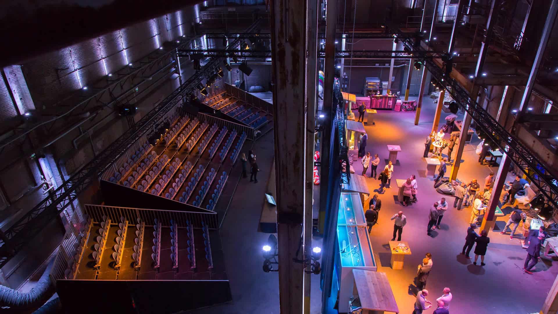 Gezicht op de industriële setting van SugarFactory met bezoekers en kleurrijke displays.