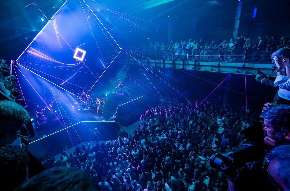Spectaculaire clubscene met laserlichten en dansende menigte.