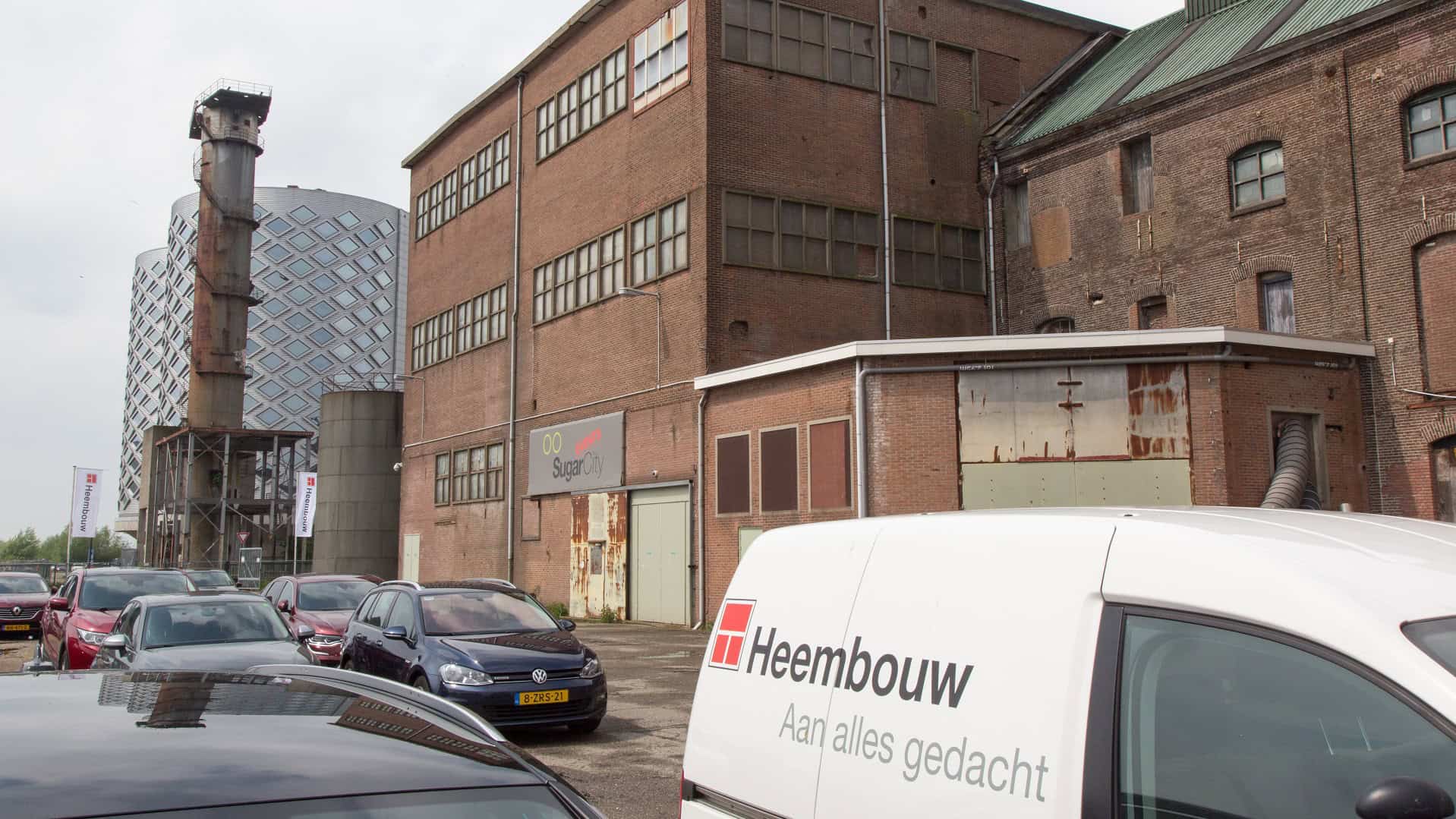 Heembouw bouwbedrijf in Rotterdam met oude fabriek en moderne kantoorgebouwen.