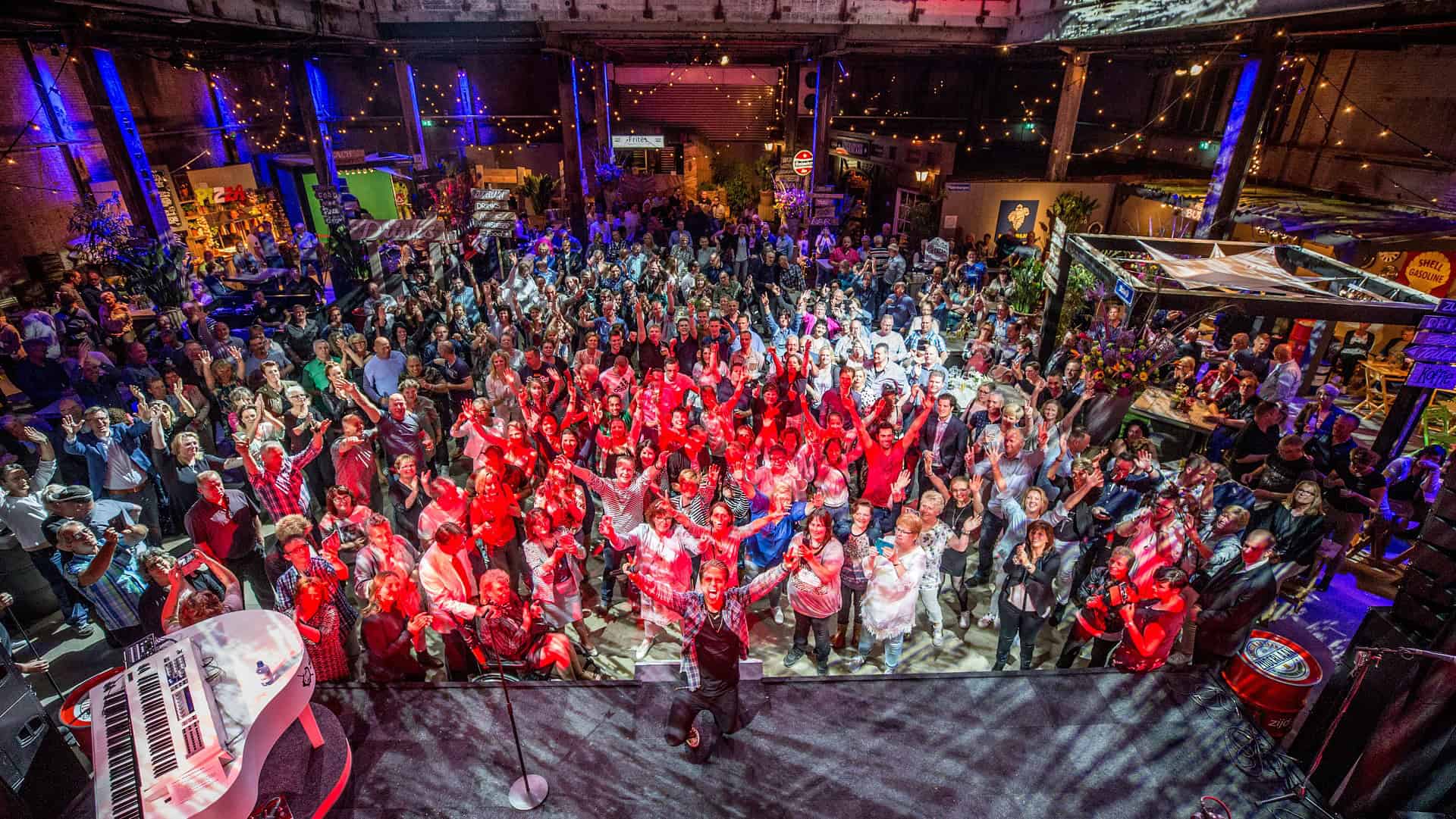 Gezellig groot feest met dansende mensen en kleurrijke verlichting.