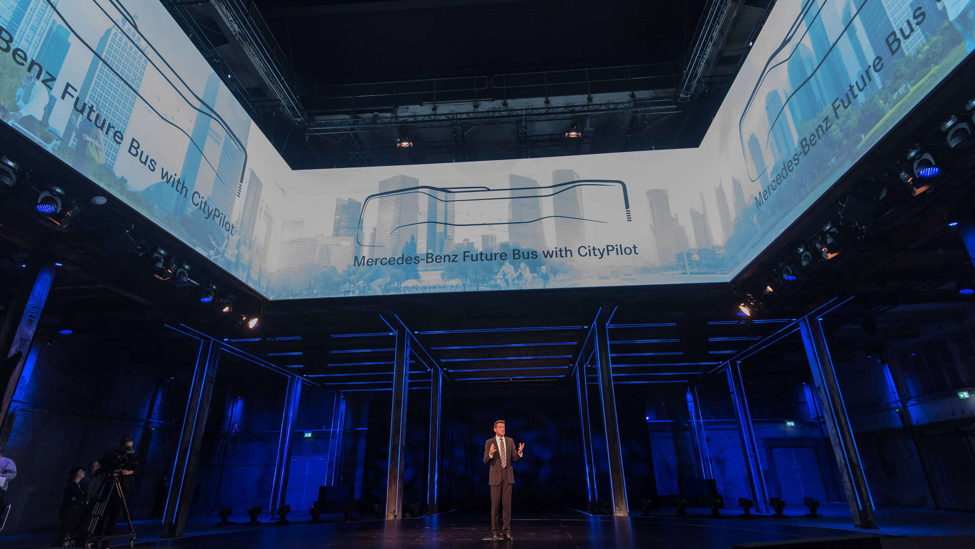 Mercedes-Benz Future Bus op een beurs met digitale schermen en podium.