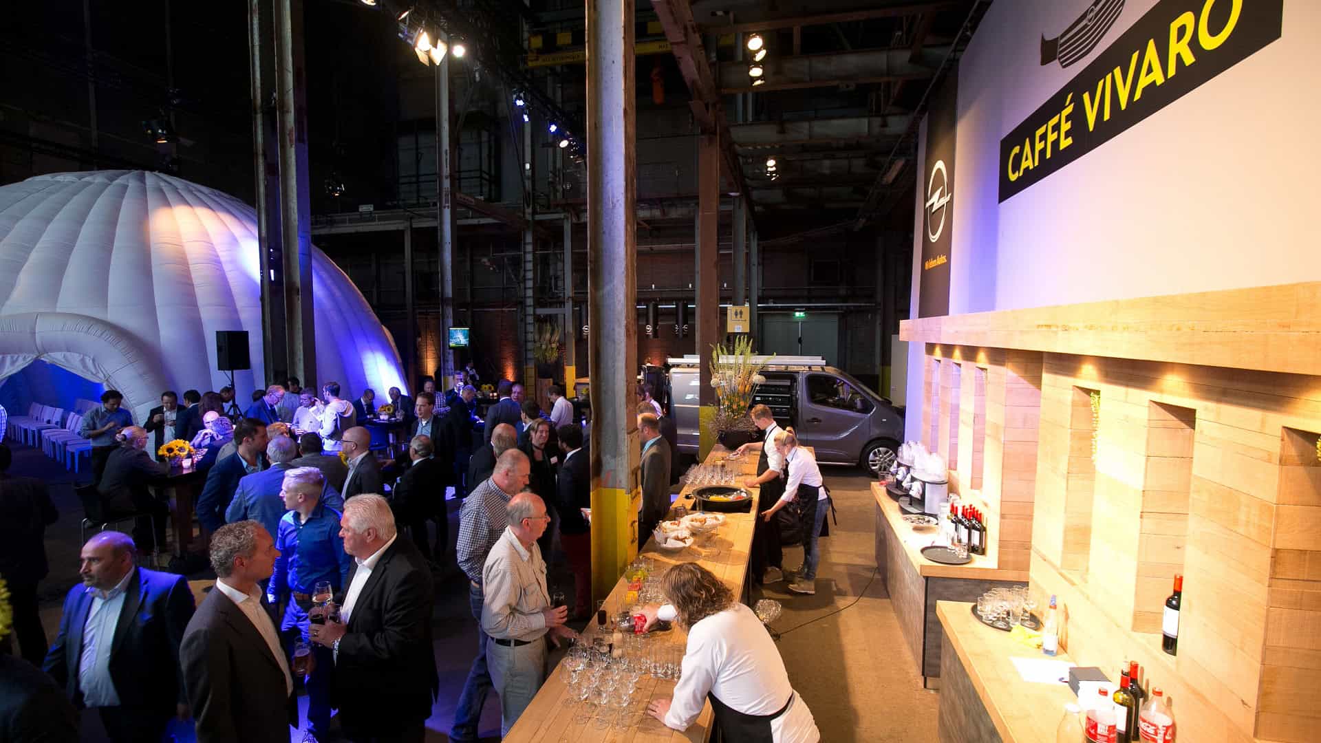 Opel auto op een evenement in de SugarFactory, omringd door bezoekers en een moderne setting.